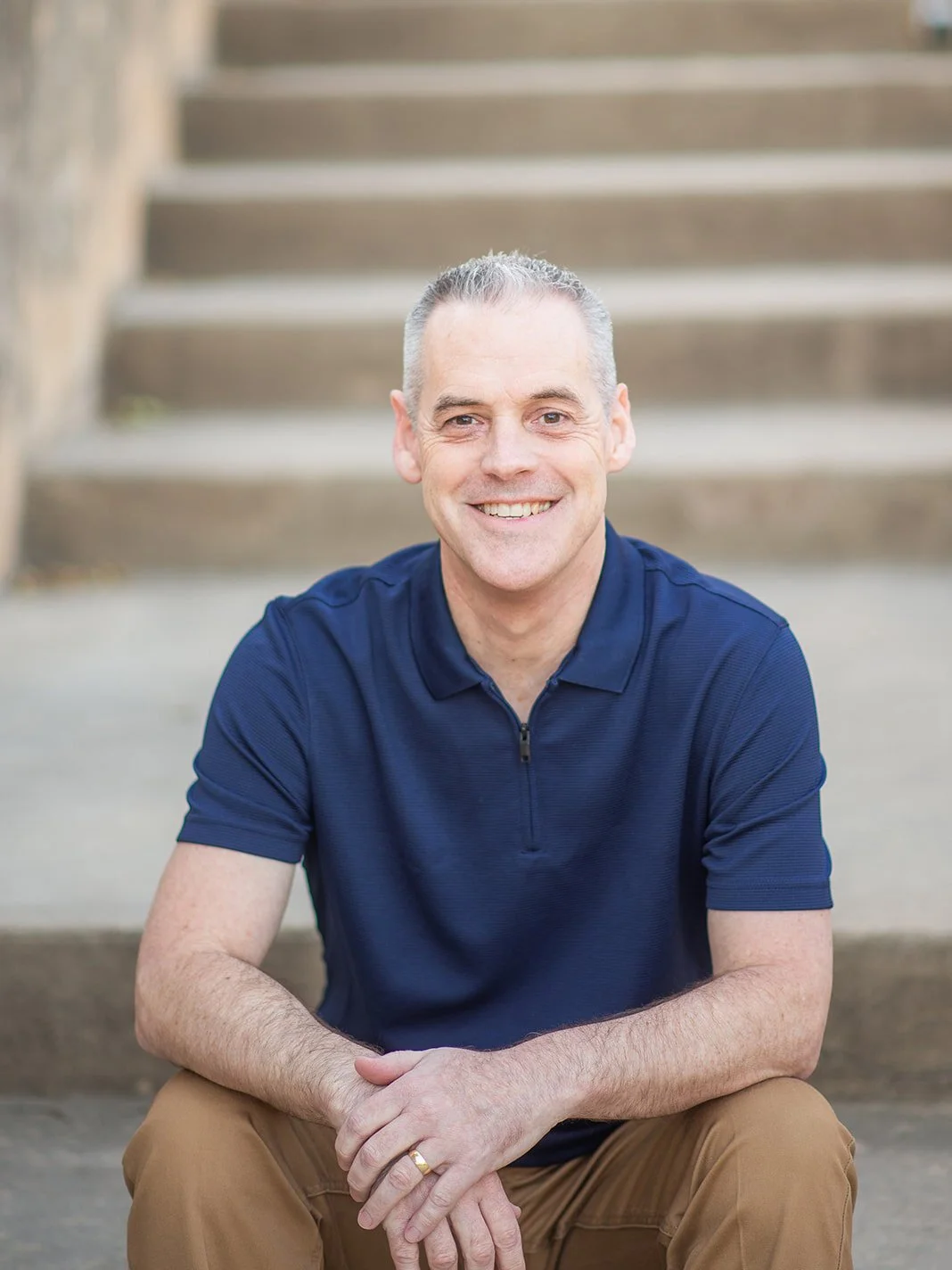 Michael Bonner LPC-S headshot. Michael is sitting on a staircase and smiling warmly.