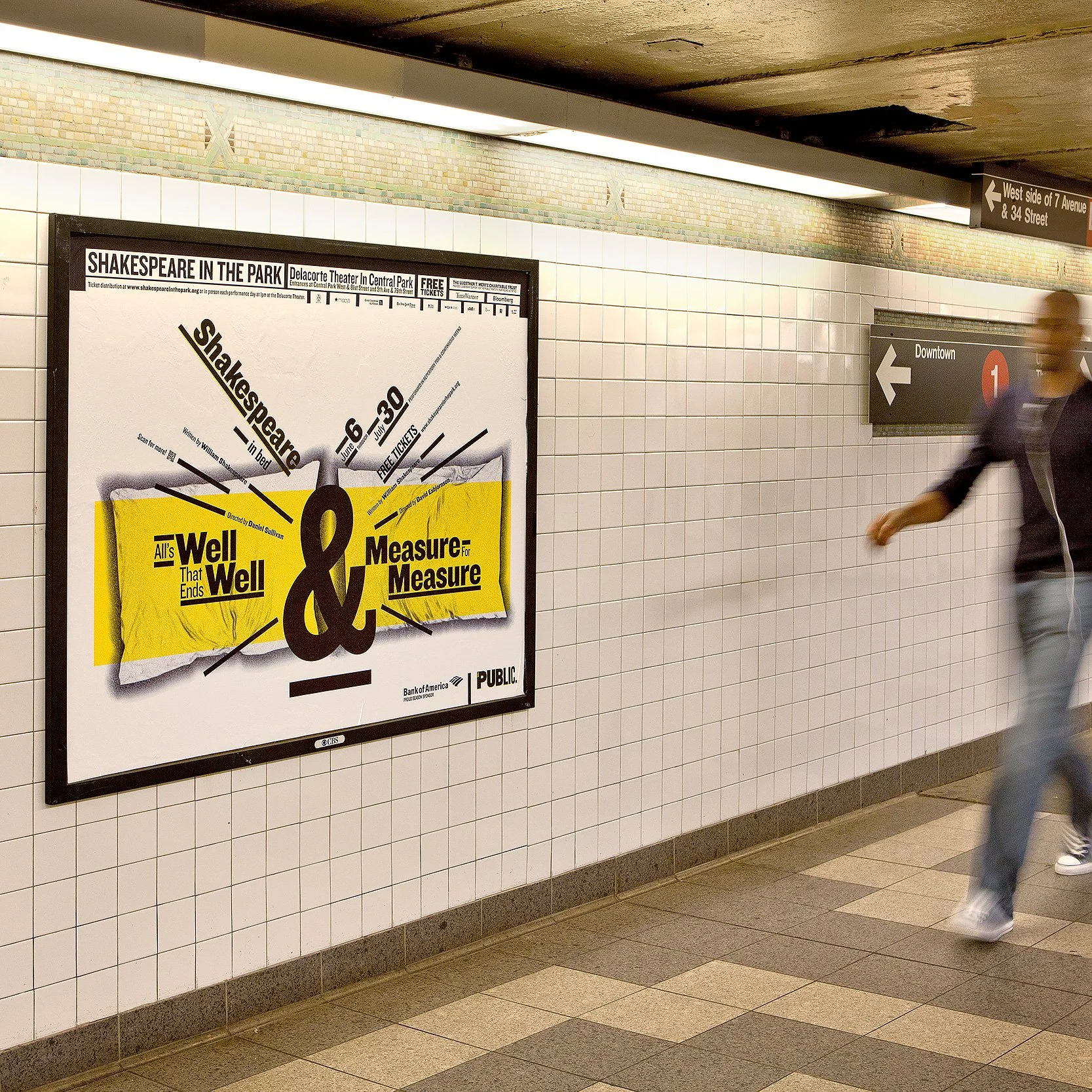 Underground subway station corridor with tiled walls, advertisements, and directional signs for downtown and 7th Avenue & 34th Street.