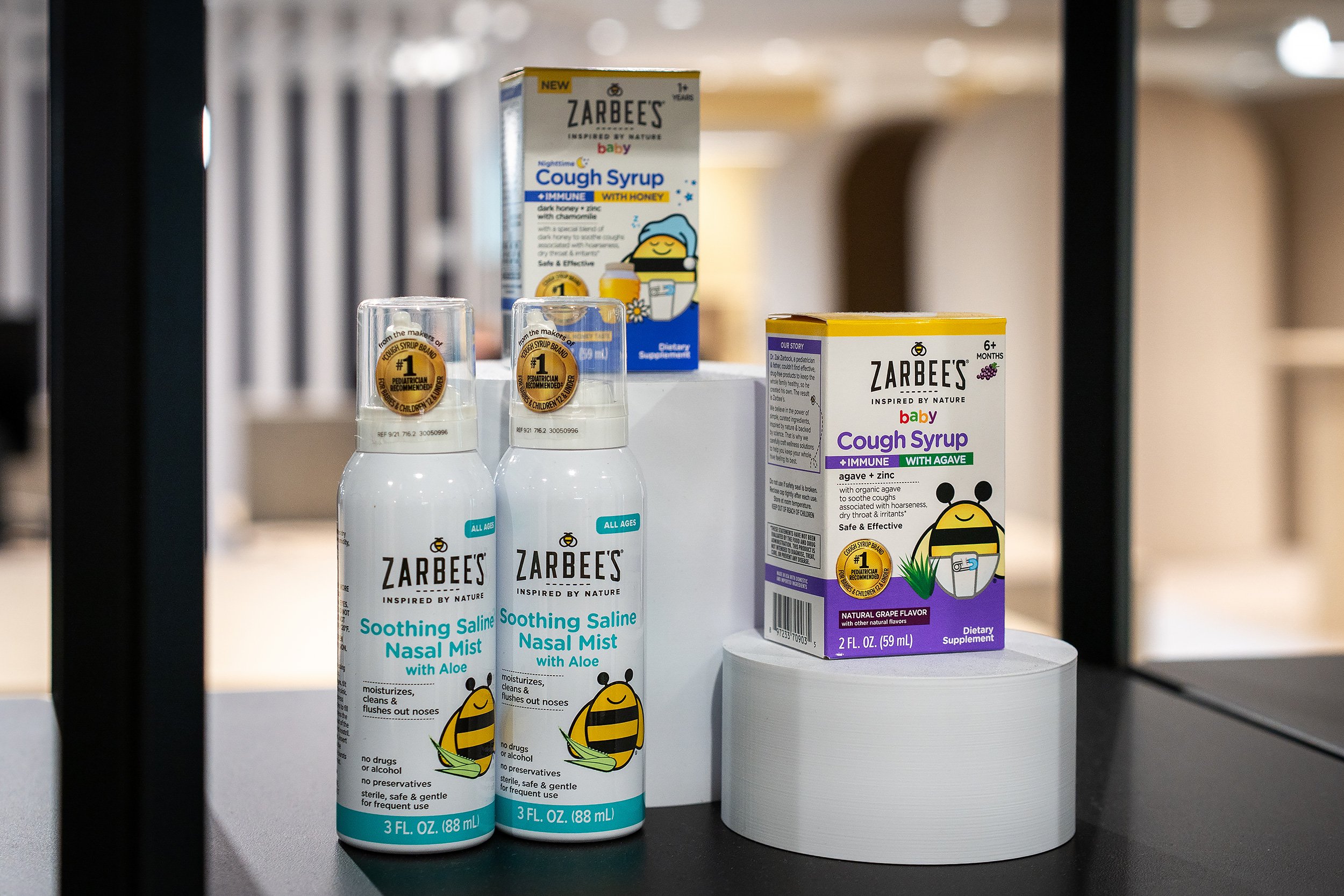 Display of Zarbee's baby cough syrup and soothing saline nasal spray on a store shelf.