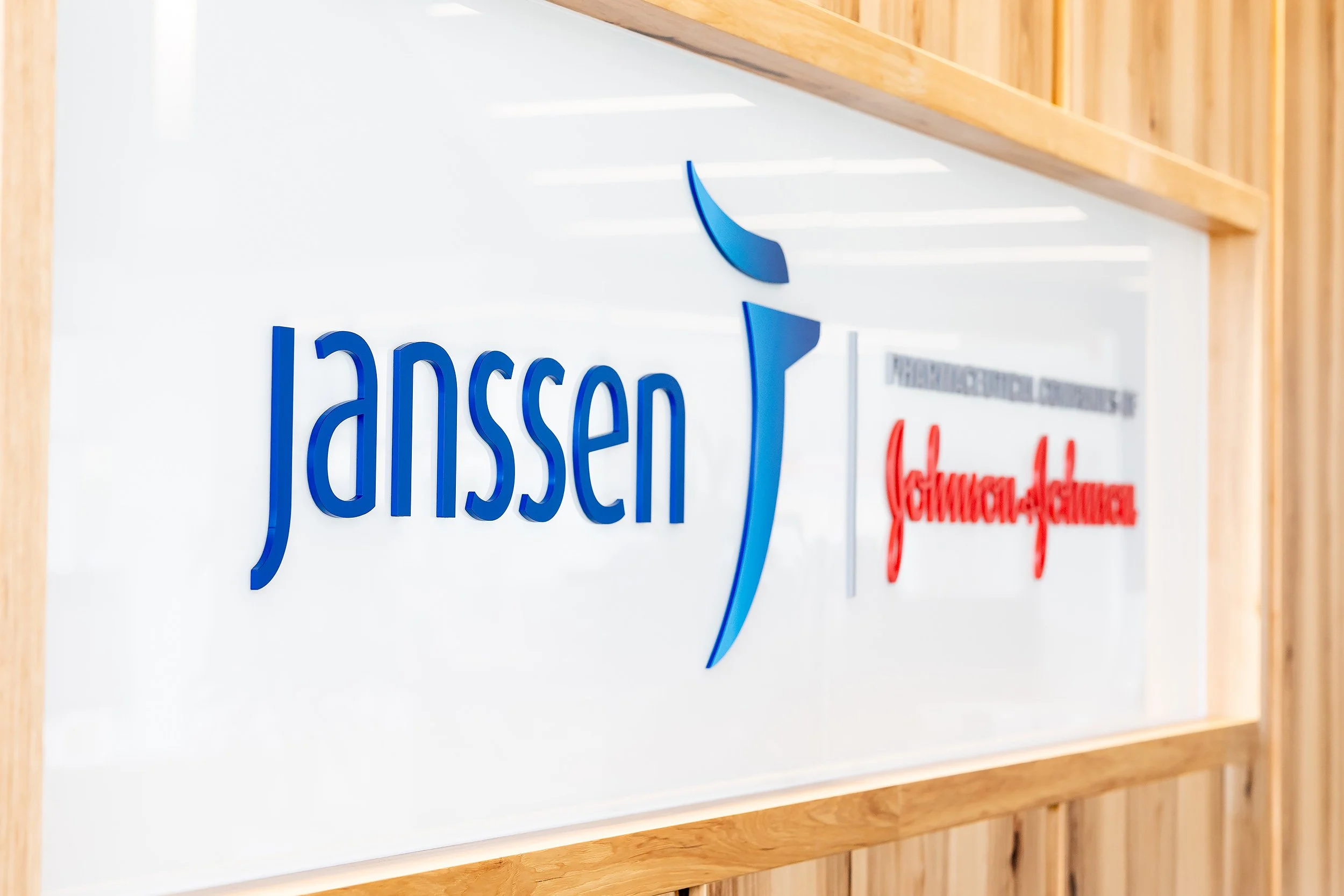 Close-up of a sign with blue and red text and design elements mounted on a wooden wall.