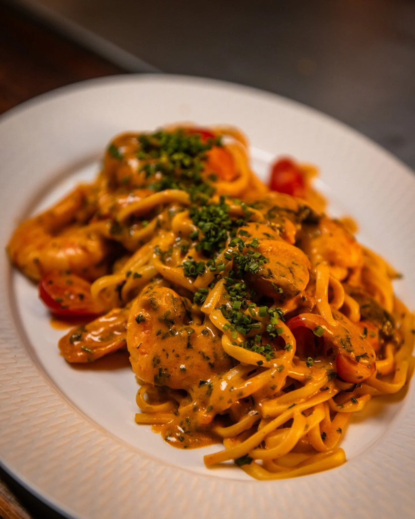 Plate of pasta with sauce, garnished with chopped herbs.