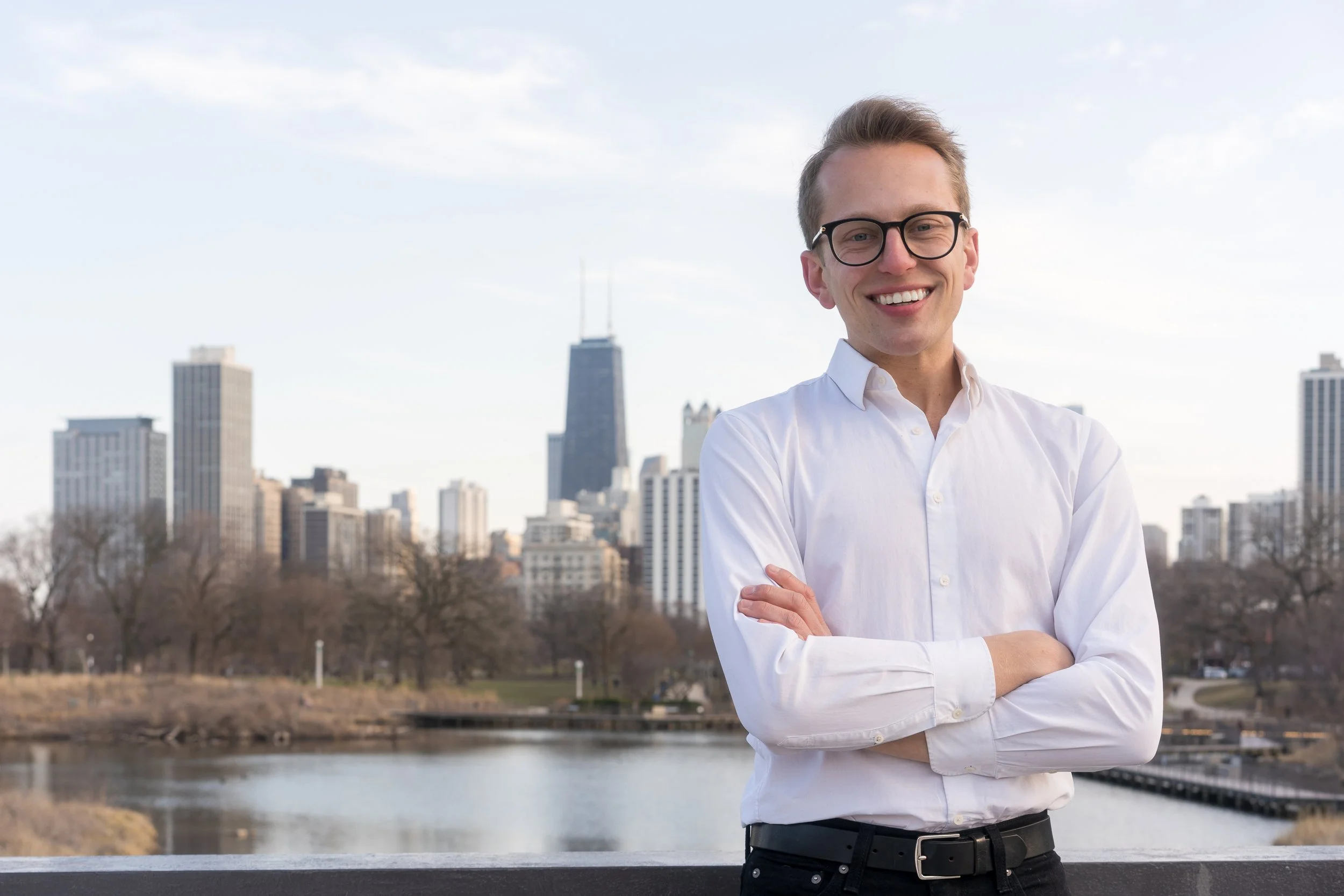 Nick smiling at the camera at Lincoln Park w/ Chicago in the background.