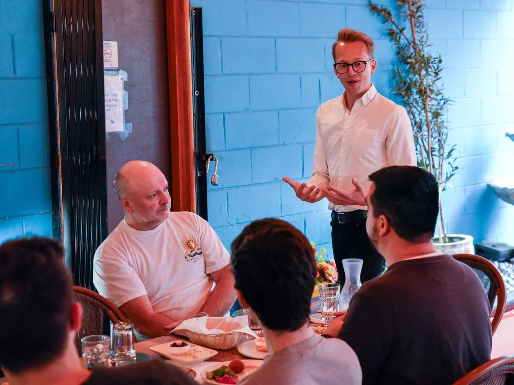 Nick speaks to folks seated at a table