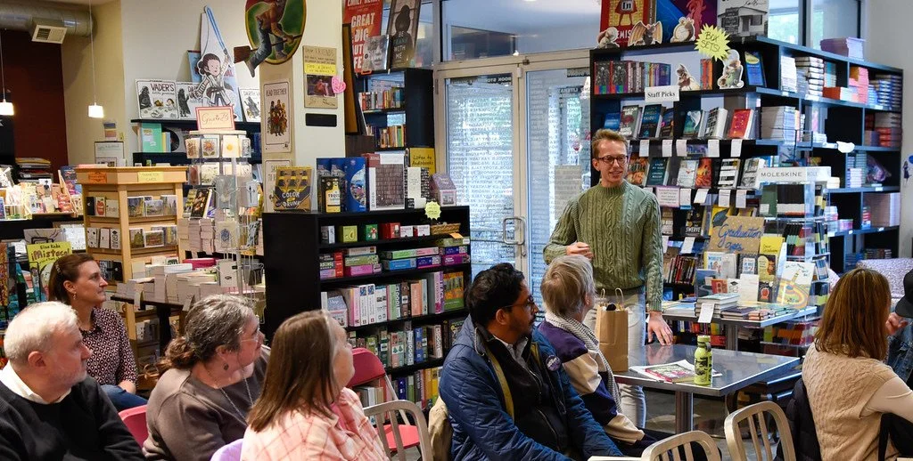 Nick speaks to a crowd at a bookstore