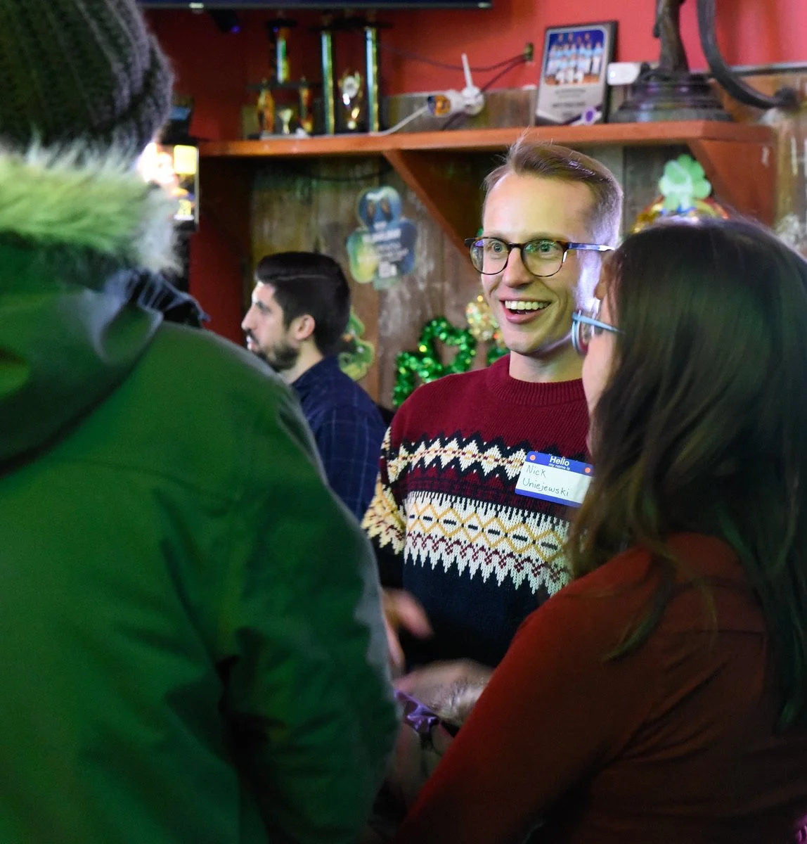 Nick speaking to voters at a bar with St. Patrick's Day decorations behind him