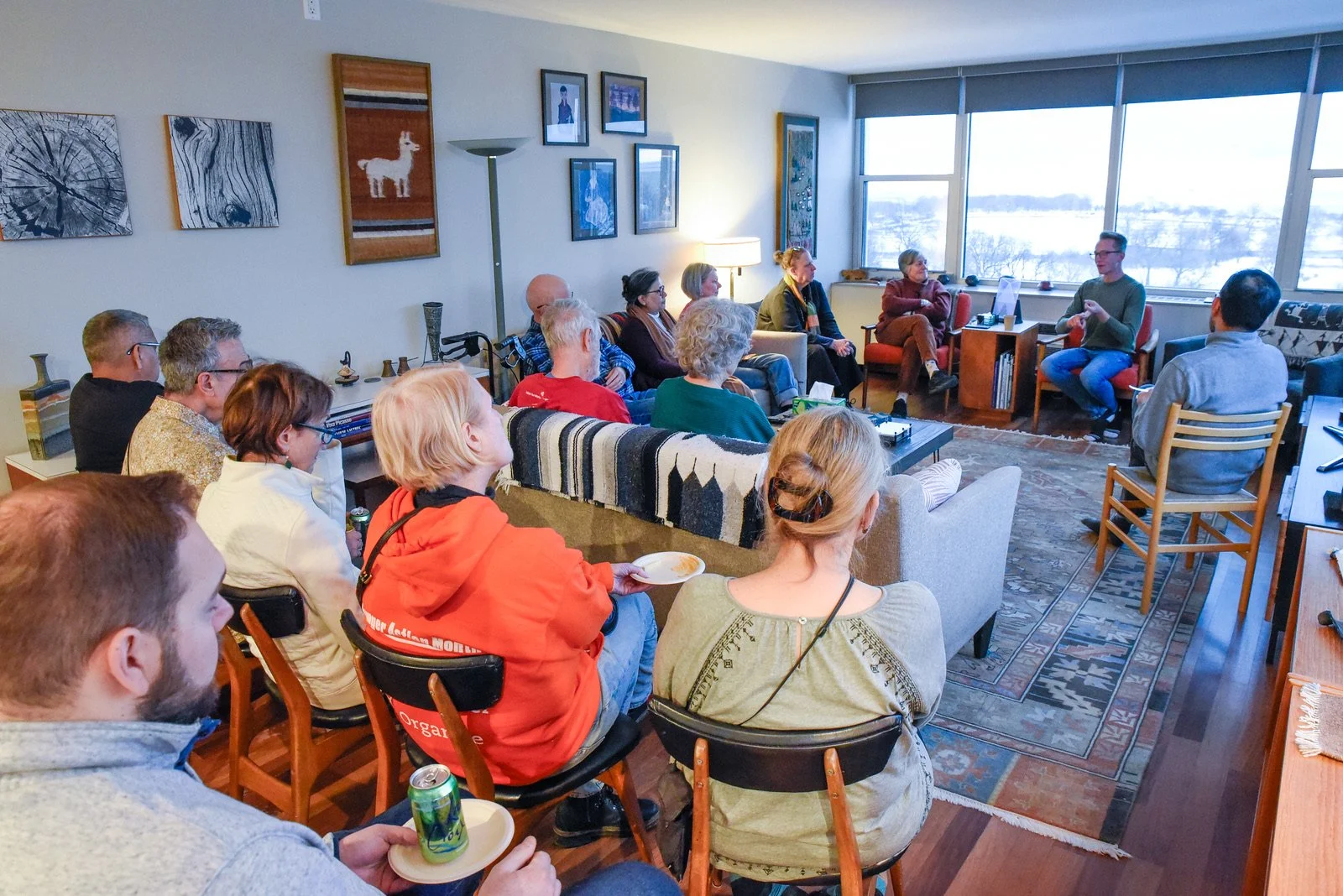 Nick in conversation at a salon with about a dozen people