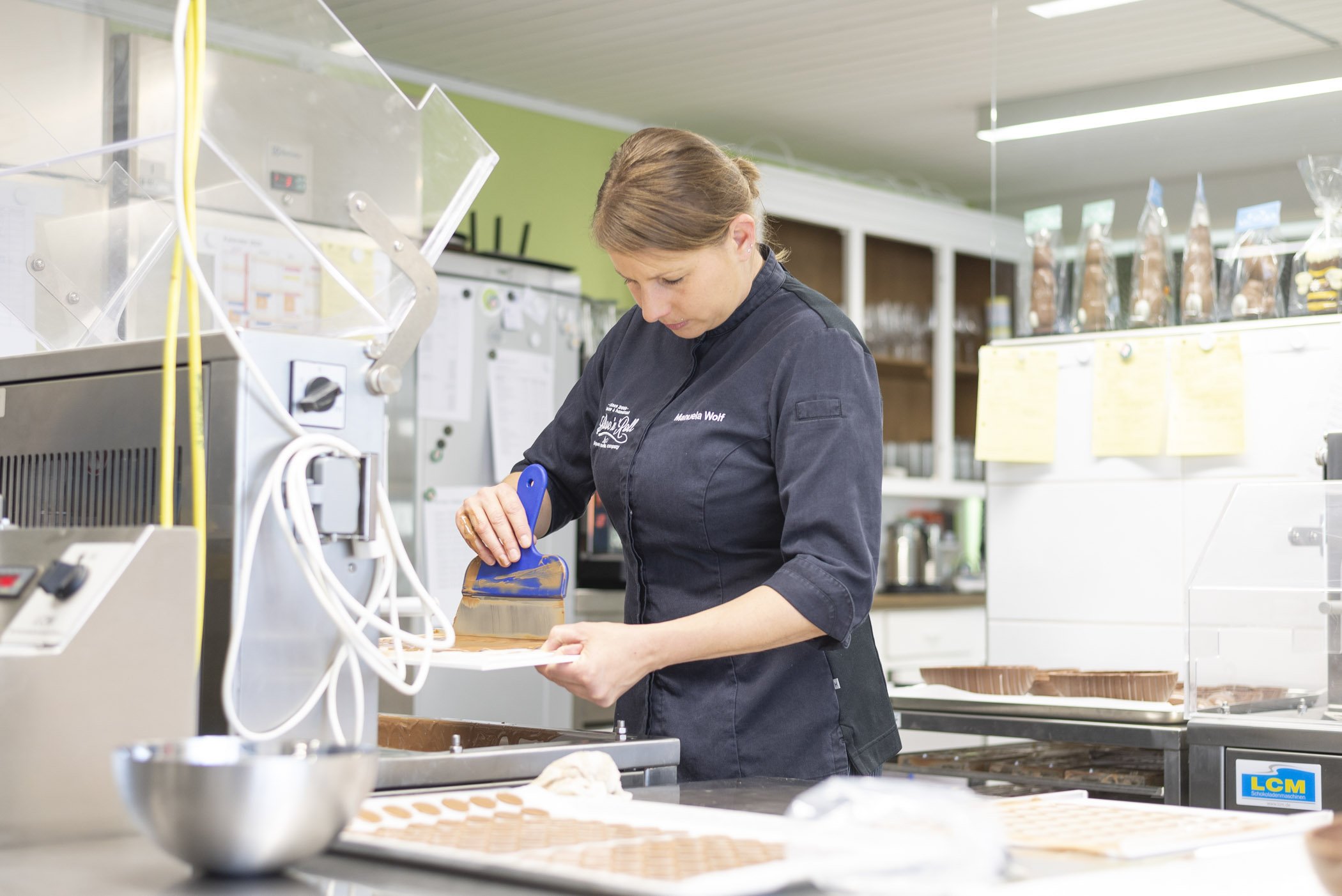 Frau in einer Bäckerei oder Konditorei arbeitet mit Schokolade.