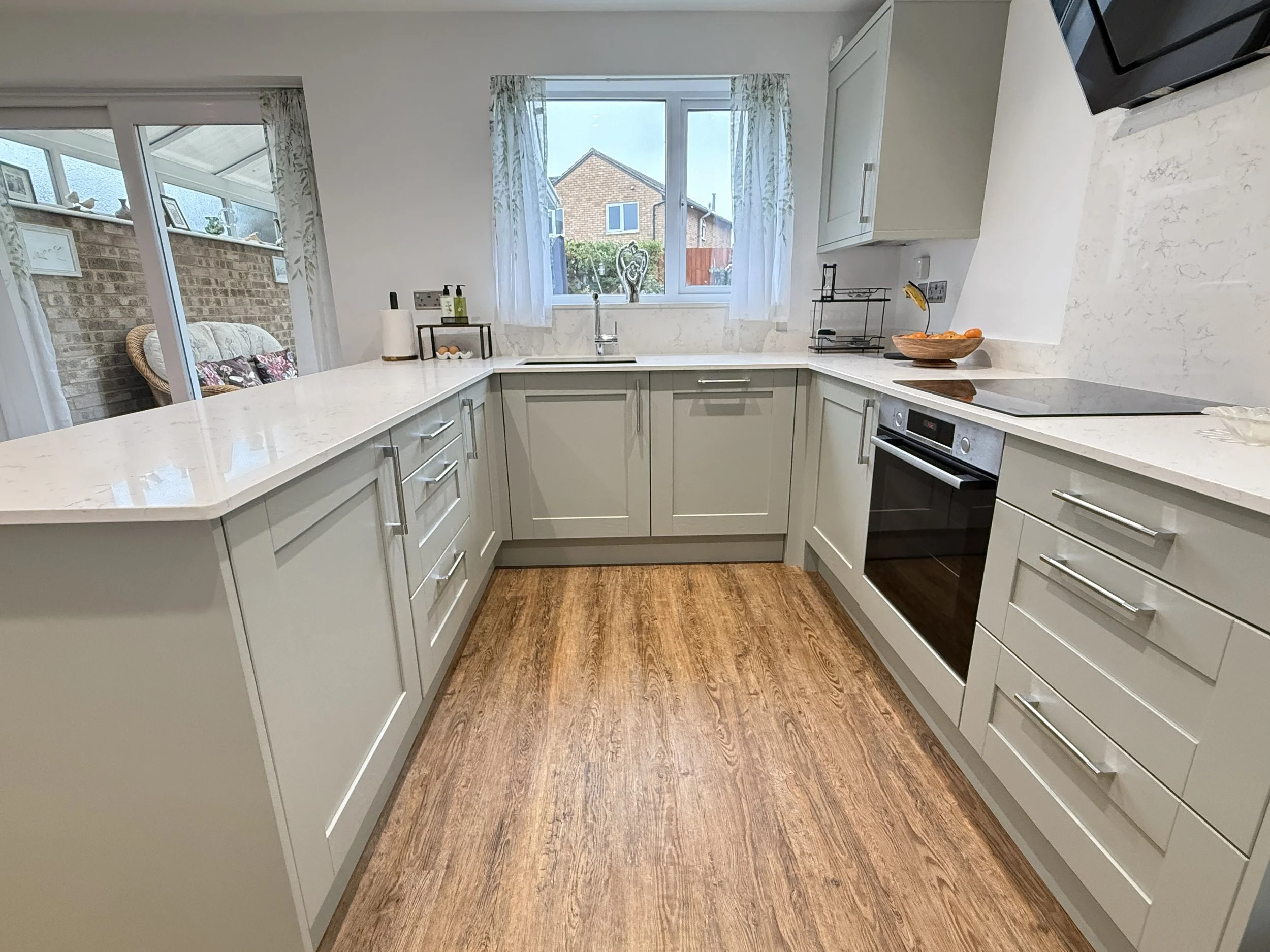 kitchen diner knock through saturn kitchens madison shaker kitchen with quartz worktop lvt oak floor dinning table and chairs built in understairs storage