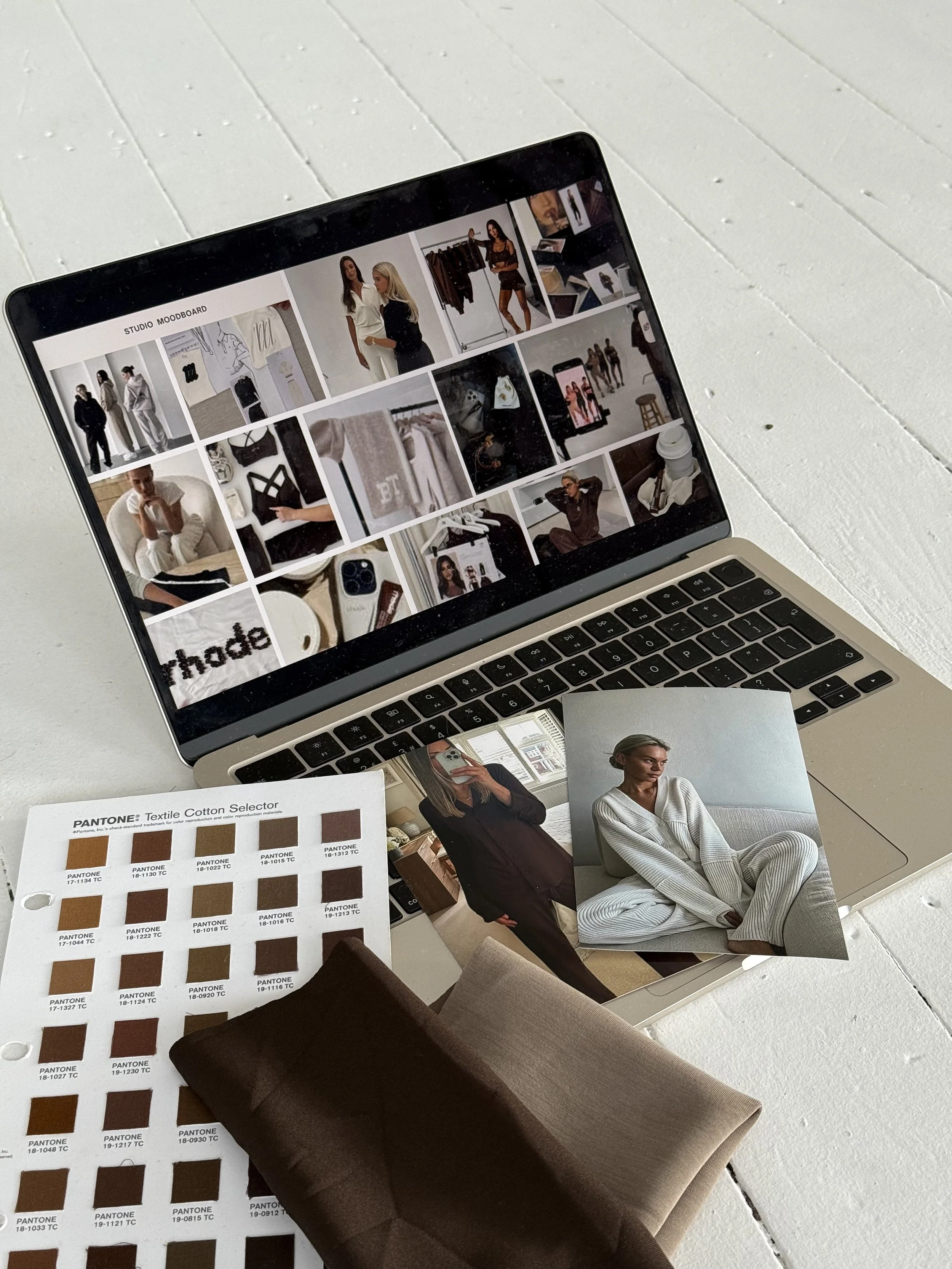 Laptop displaying a moodboard with fashion photos, color swatches and fabric samples for clothing design.