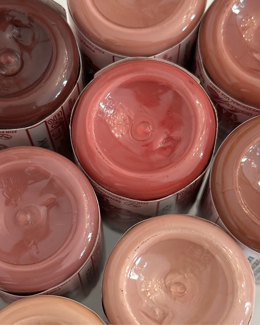 Multiple jars of baby food arranged in a close-up shot, showing the variety of fruit and vegetable purees inside.
