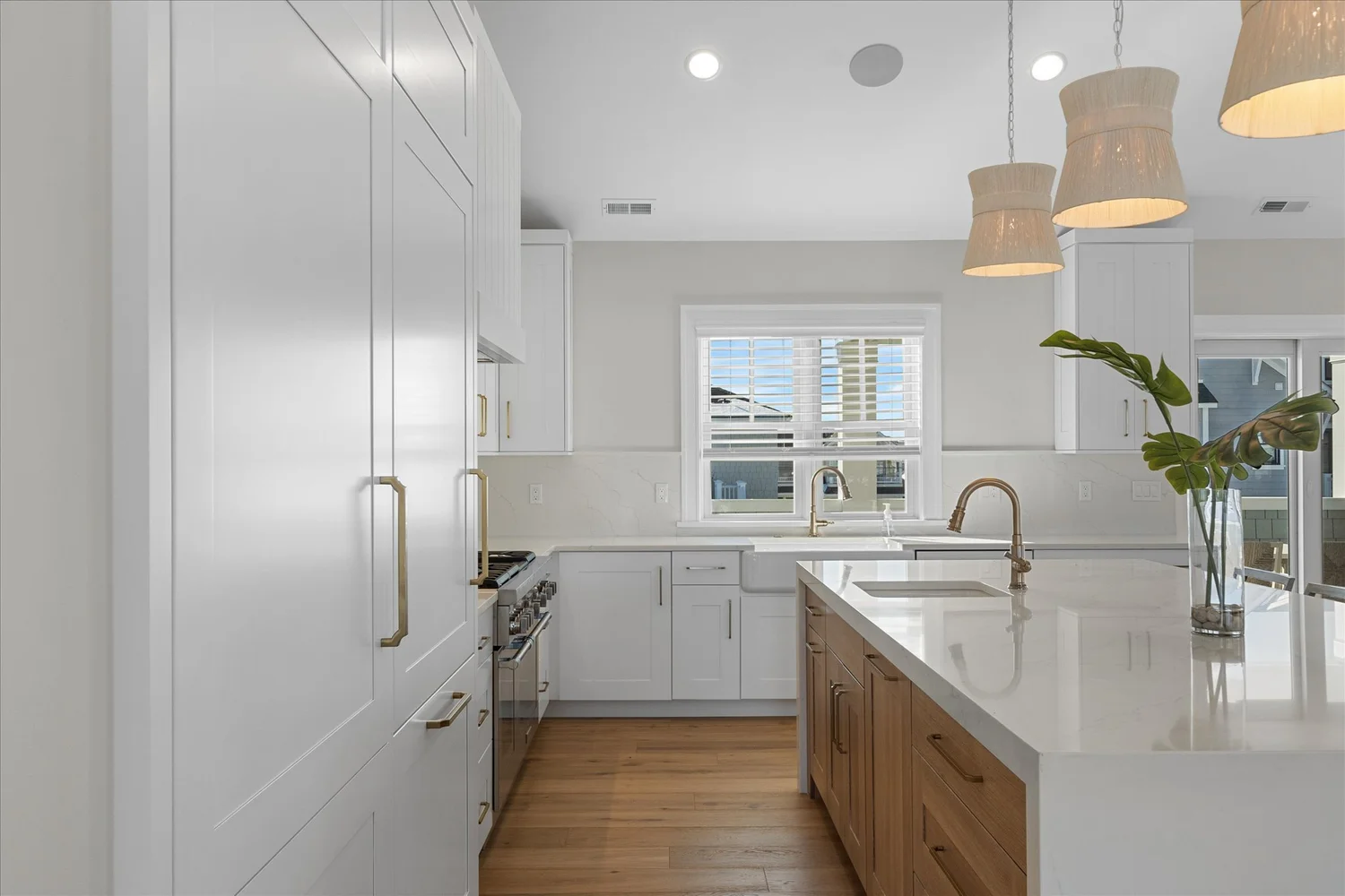 Kitchen with a large island, rattan pendants and a paneled refrigerator, 227 107th St, Stone Harbor, NJ