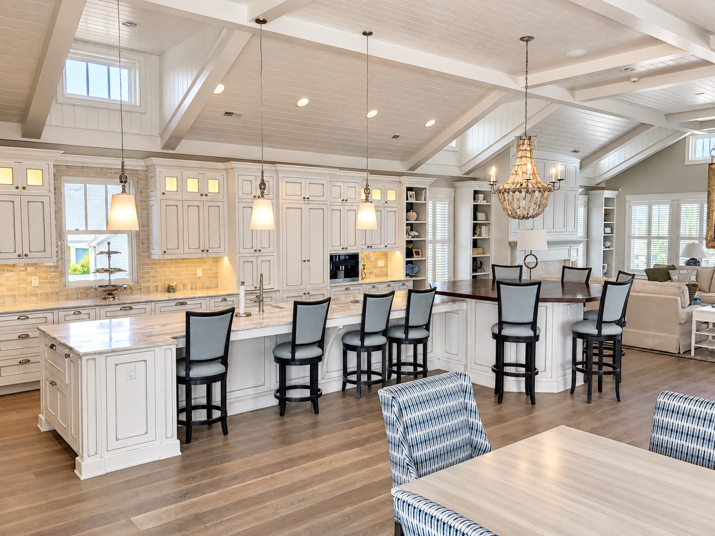 White kitchen with large islands and chandeliers under a vaulted ceiling, Stone Harbor NJ custom home