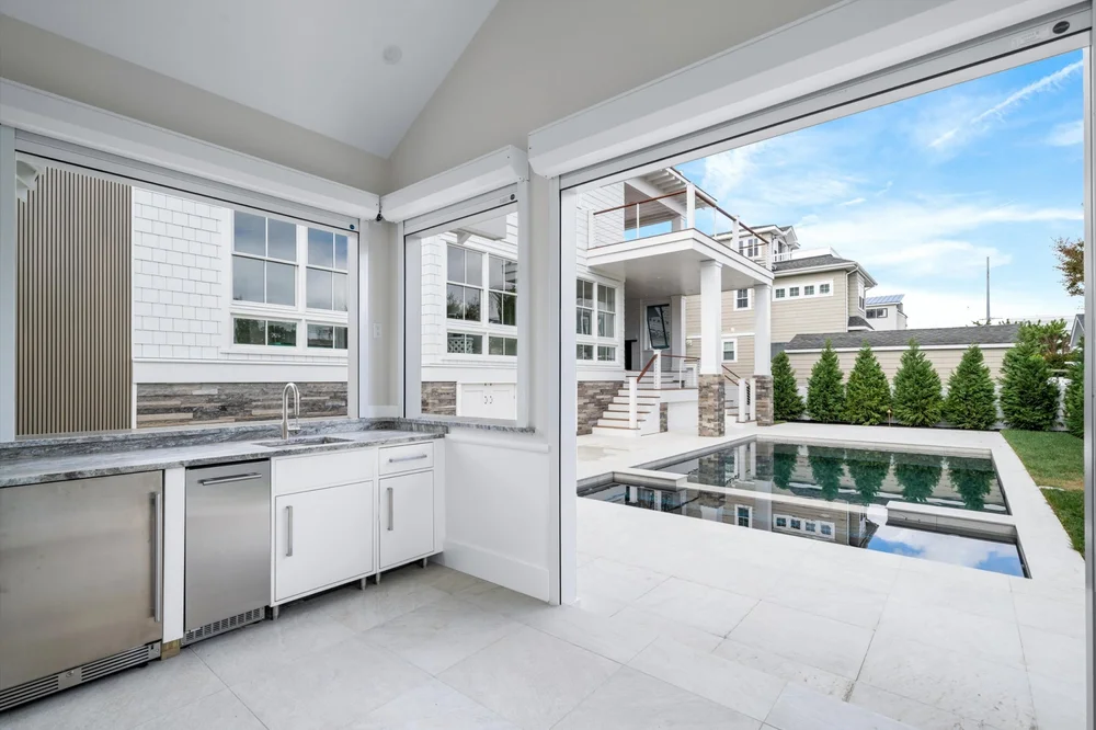 View of a gunite pool and spa from inside a custom pool house