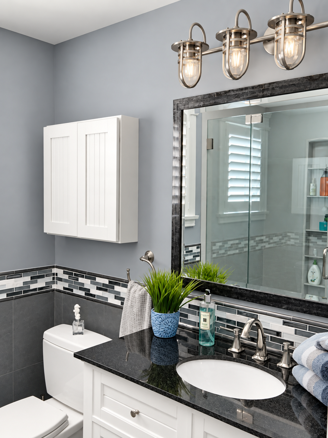 New bathroom with a black countertop, tile accent and glass shower in the renovated Sea Isle City duplex