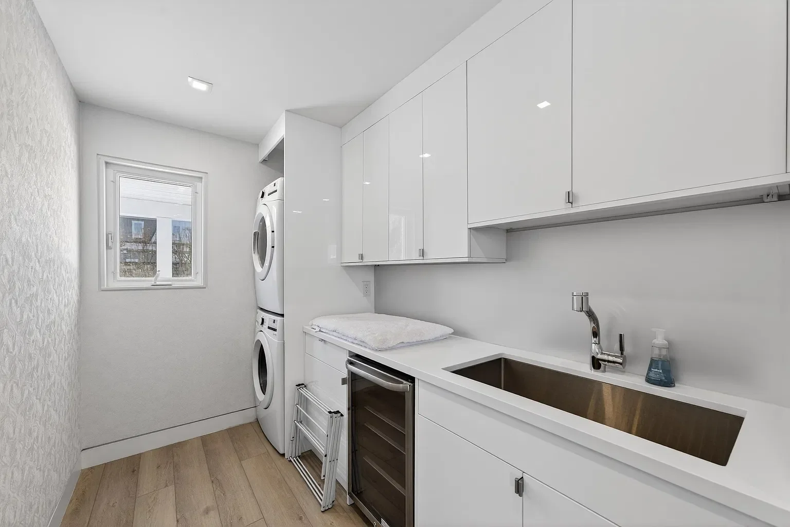 New laundry room with stacked washer and dryer and a utility sink, 107 116th St, Stone Harbor, NJ