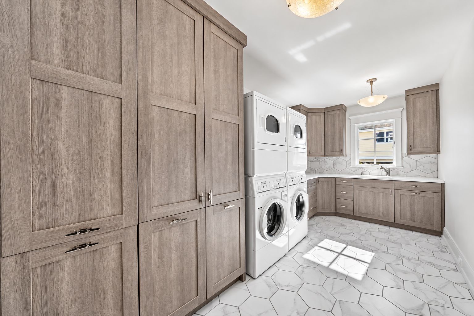 Custom laundry room with stacked washer and dryer and wood cabinets, 213 57th St, Avalon, NJ
