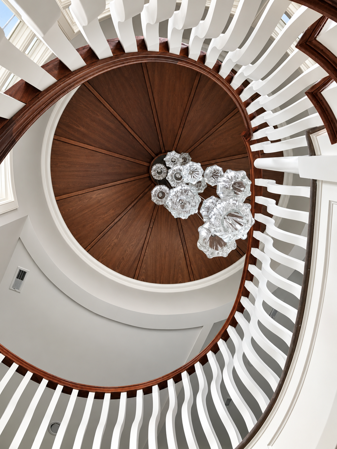 Curved staircase rising to a round mahogany ceiling with a hand-blown glass chandelier, 141 99th St, Stone Harbor, NJ