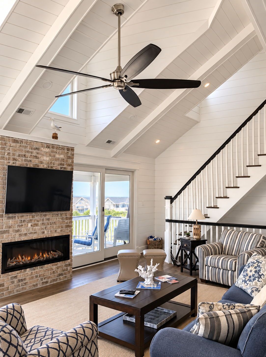 Brick fireplace wall and staircase in the vaulted living room of the renovated Sea Isle City duplex