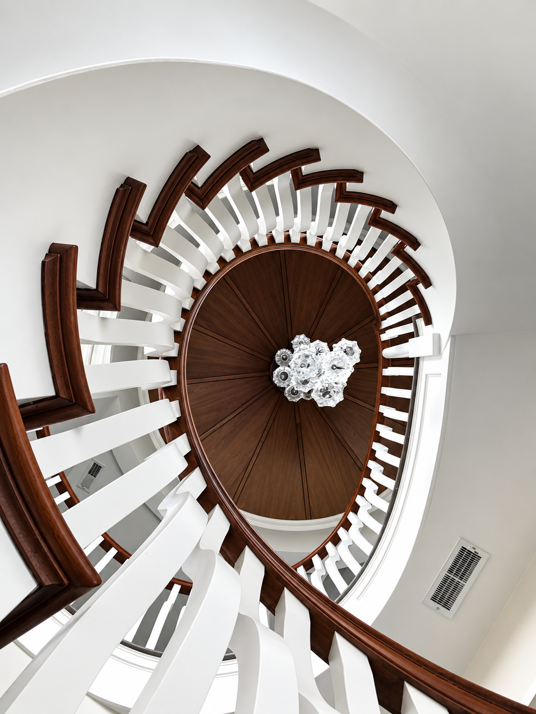 Spiral staircase with mahogany treads and hand-blown chandelier, Stone Harbor NJ custom home
