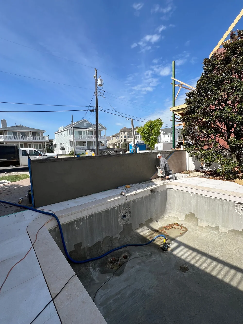 Pool renovation in progress at the Jersey Shore with the old finish removed and new coping and porcelain patio installed