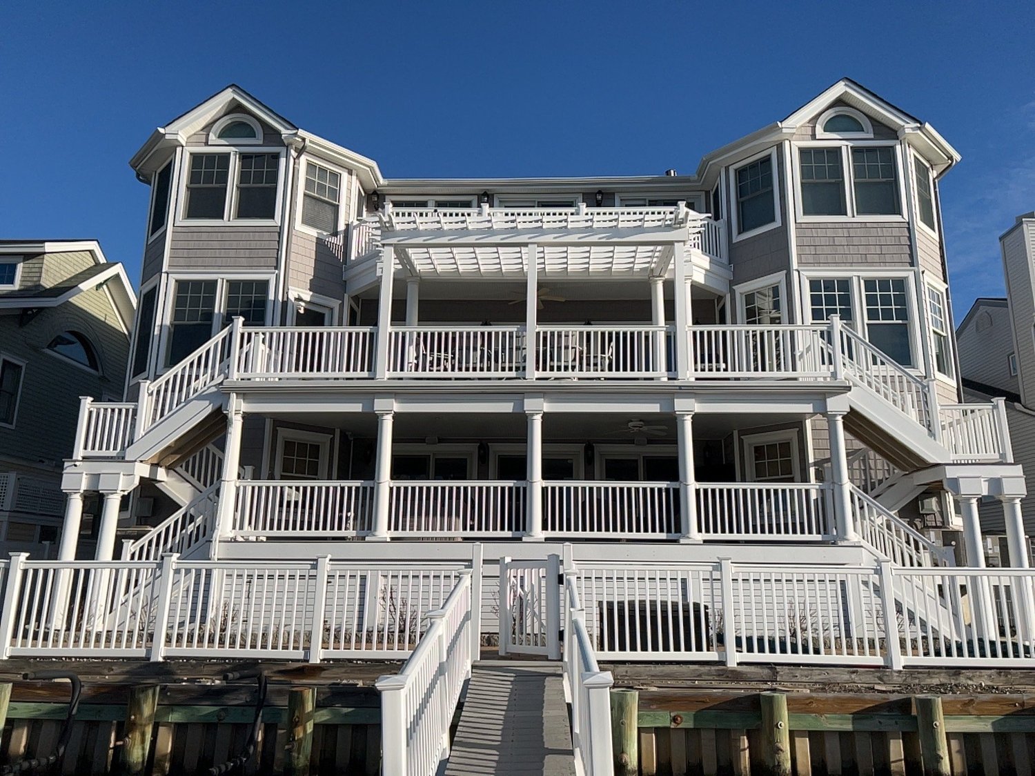 Rear of a renovated Sea Isle City home with new fiberglass decks and white railings