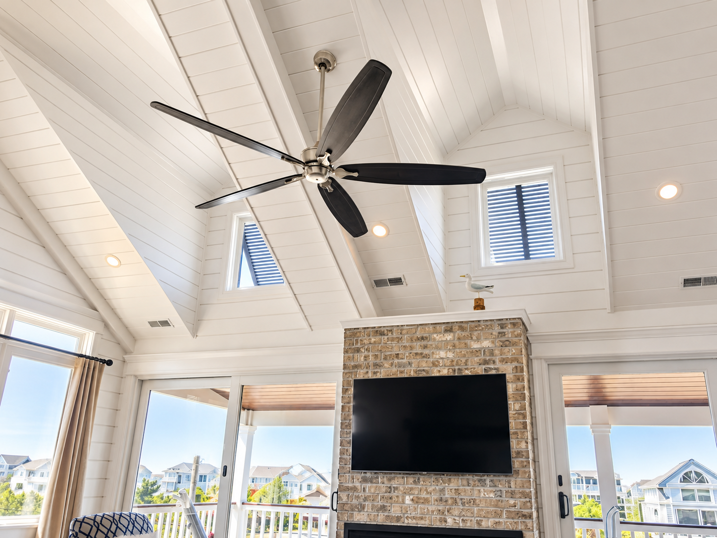 Vaulted shiplap ceiling and brick fireplace wall in the great room of the renovated Sea Isle City duplex