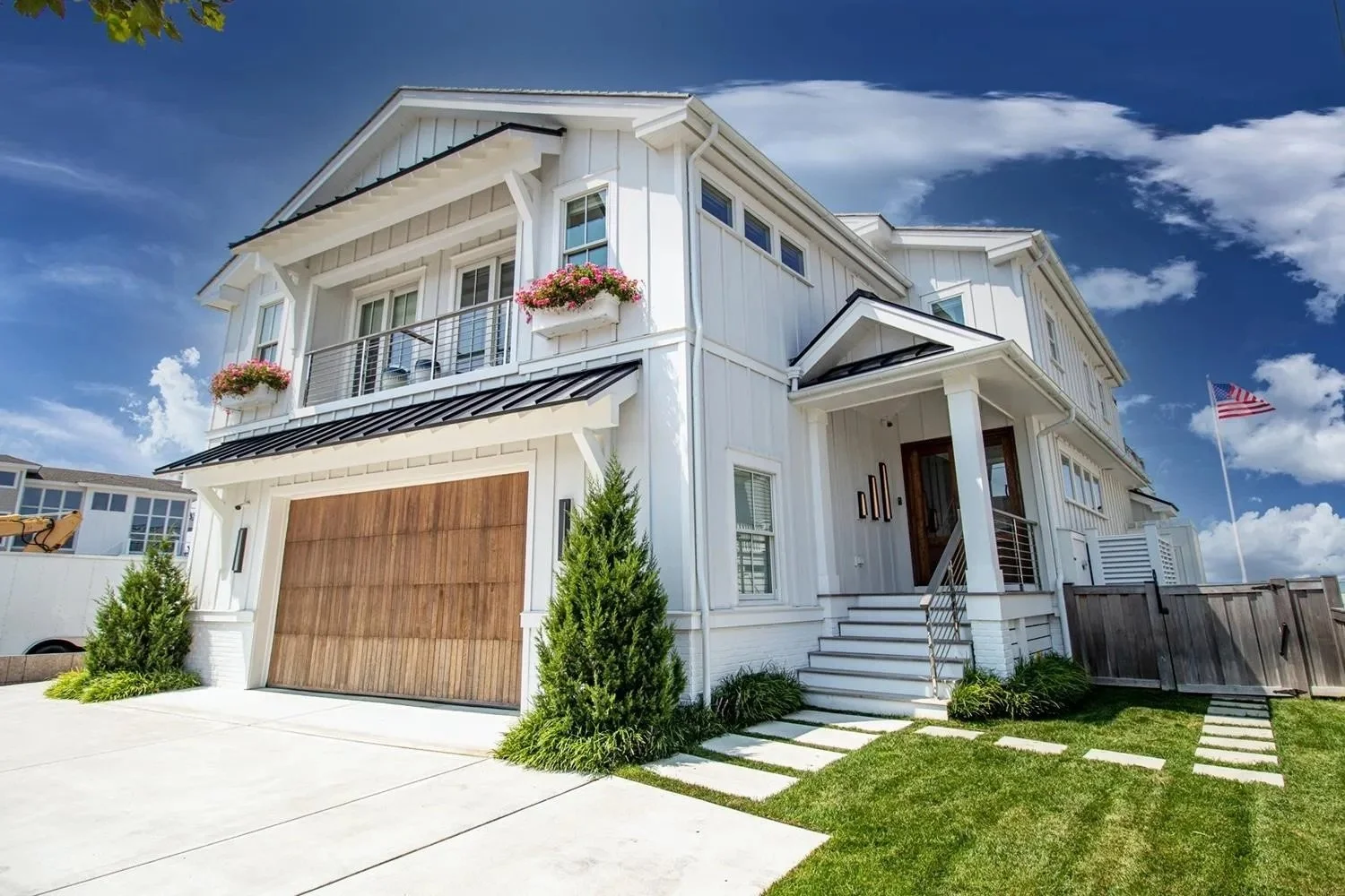 Exterior of a renovated shore home with wood garage door and front porch, Avalon NJ