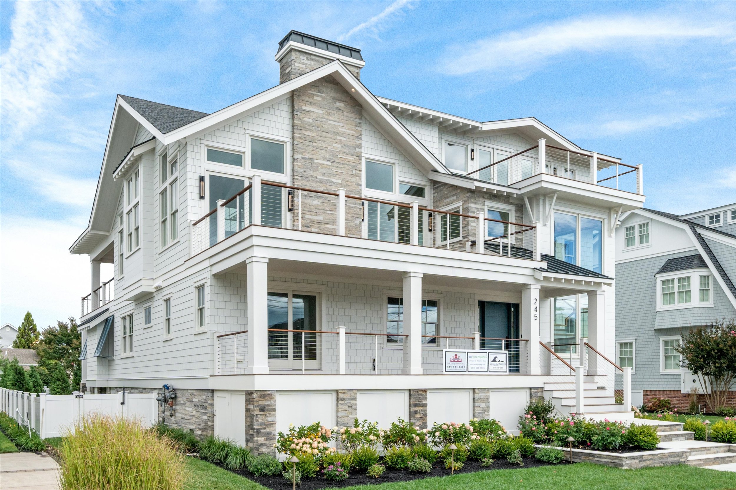 Front of the new custom home with covered porches and landscaping, 245 57th St, Avalon, NJ