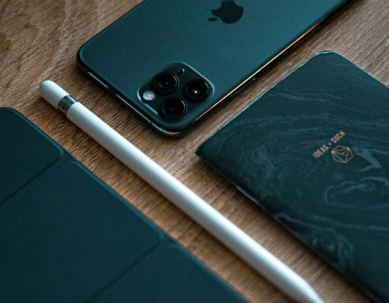 An iphone and ipad in slick teal cases laid flat on a desk surface