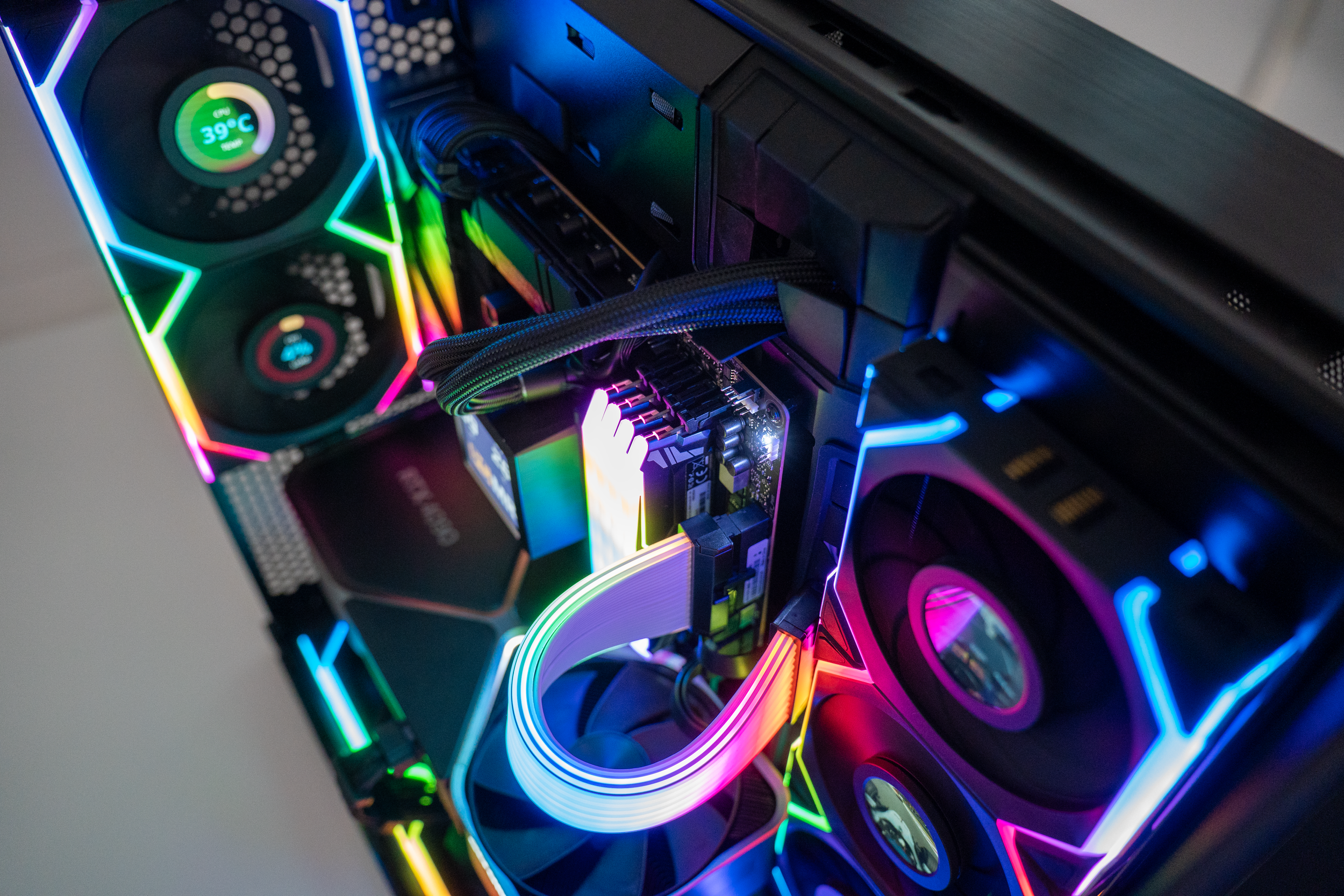 Close-up of a gaming computer interior with illuminated RGB lighting on fans, graphics card, and components.
