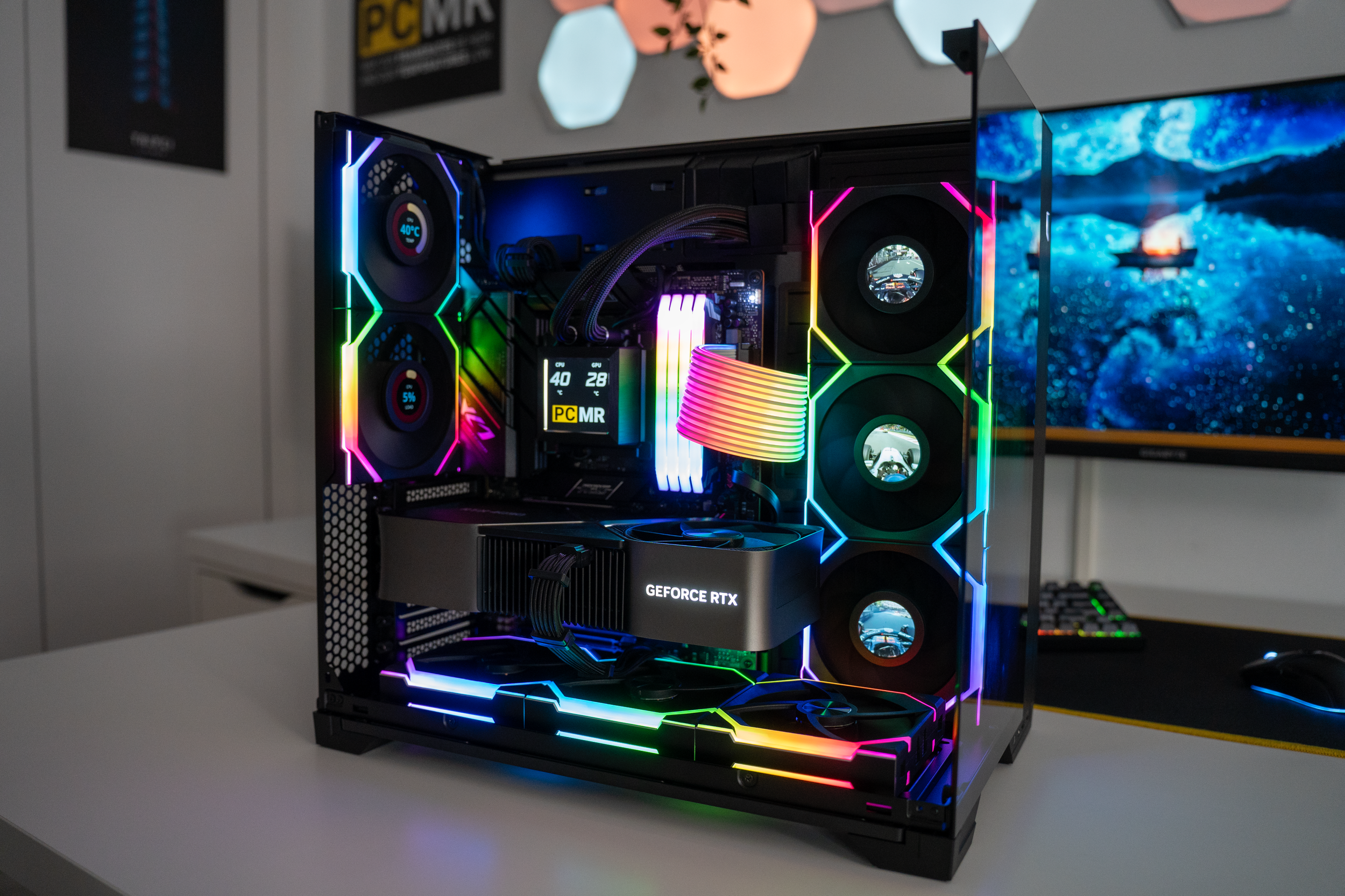 A gaming or high-performance computer built with RGB lighting, featuring multiple fans, a graphics card labeled "GEFORCE RTX," and various components illuminated with colorful lights.