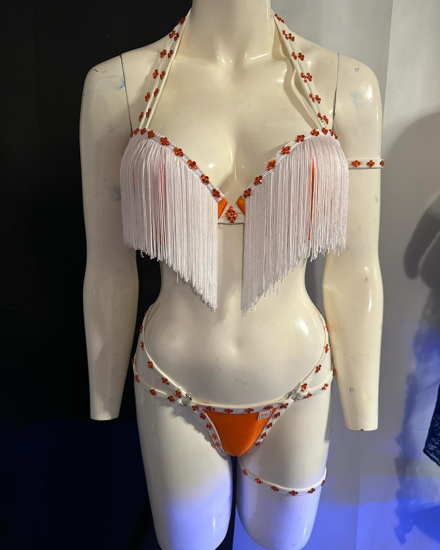 Mannequin wearing a fringed bikini with floral embellishments