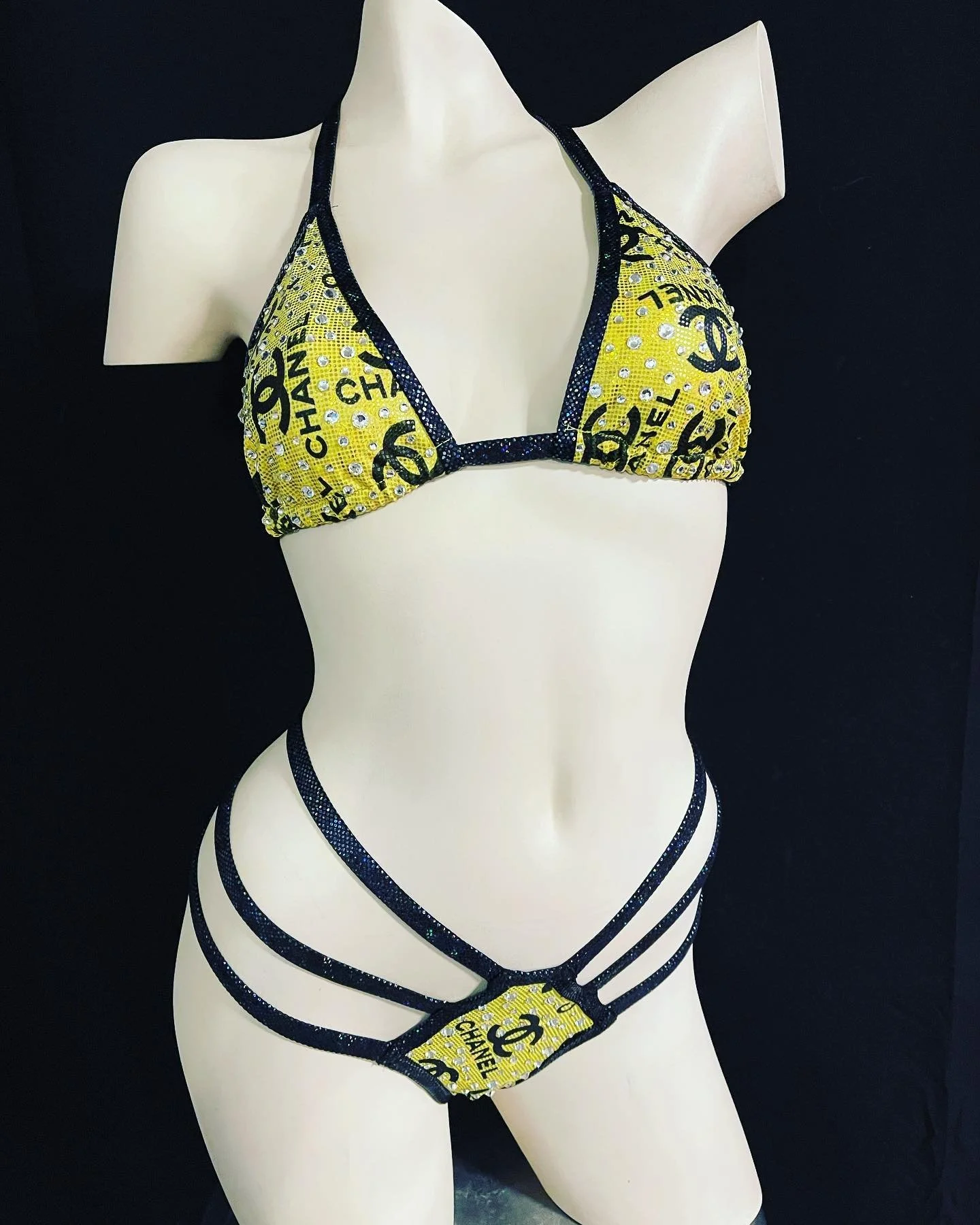 Mannequin wearing yellow and black bikini with designer logo