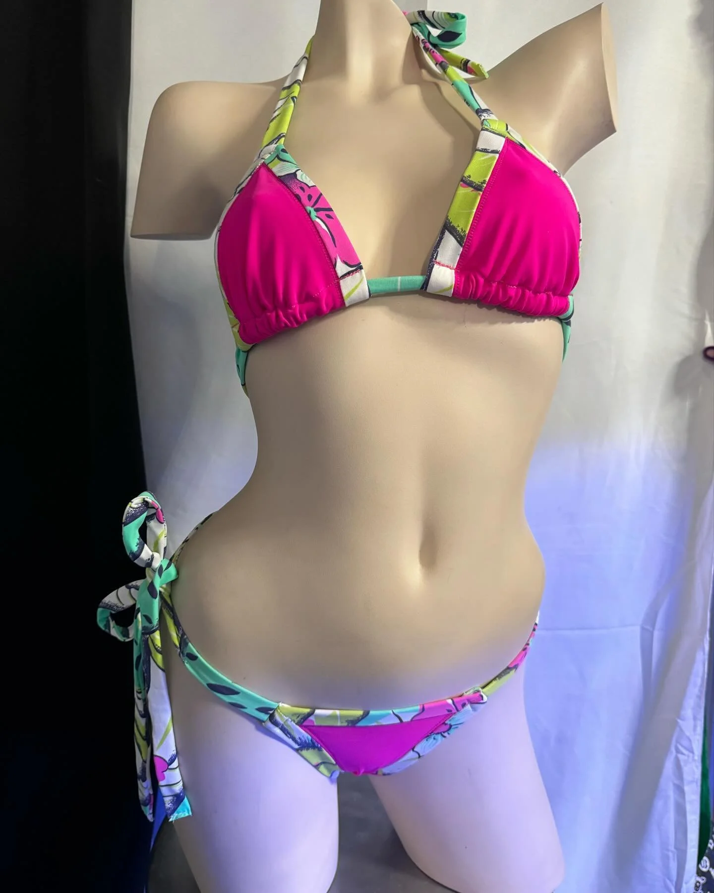 Mannequin wearing a pink and multicolored geometric bikini
