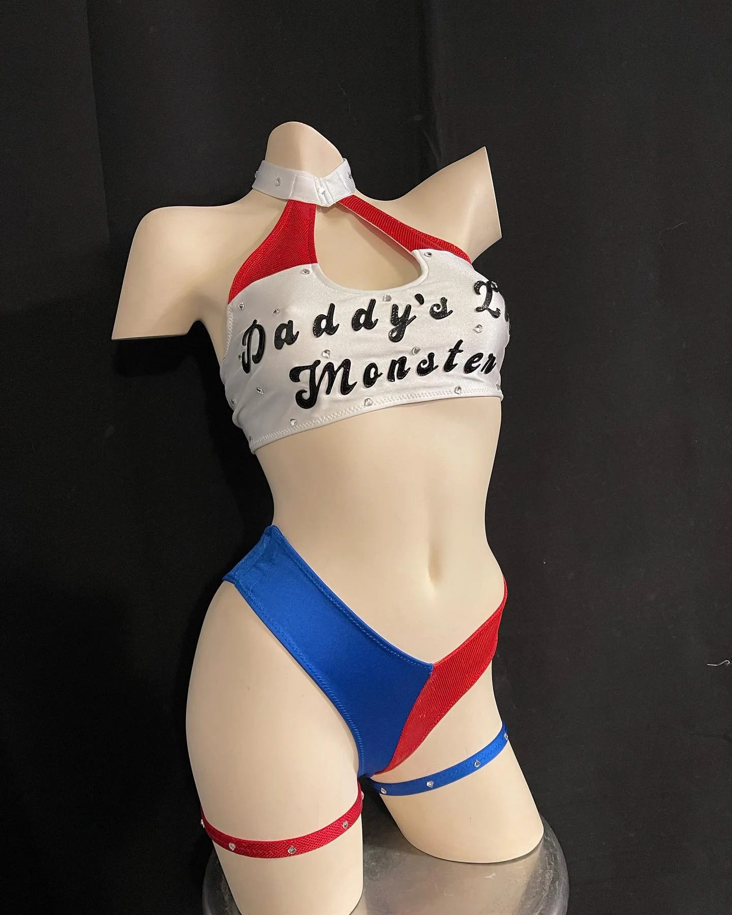 Mannequin wearing a red, blue, and white outfit with the text 'Daddy's Lil Monster' on the top.