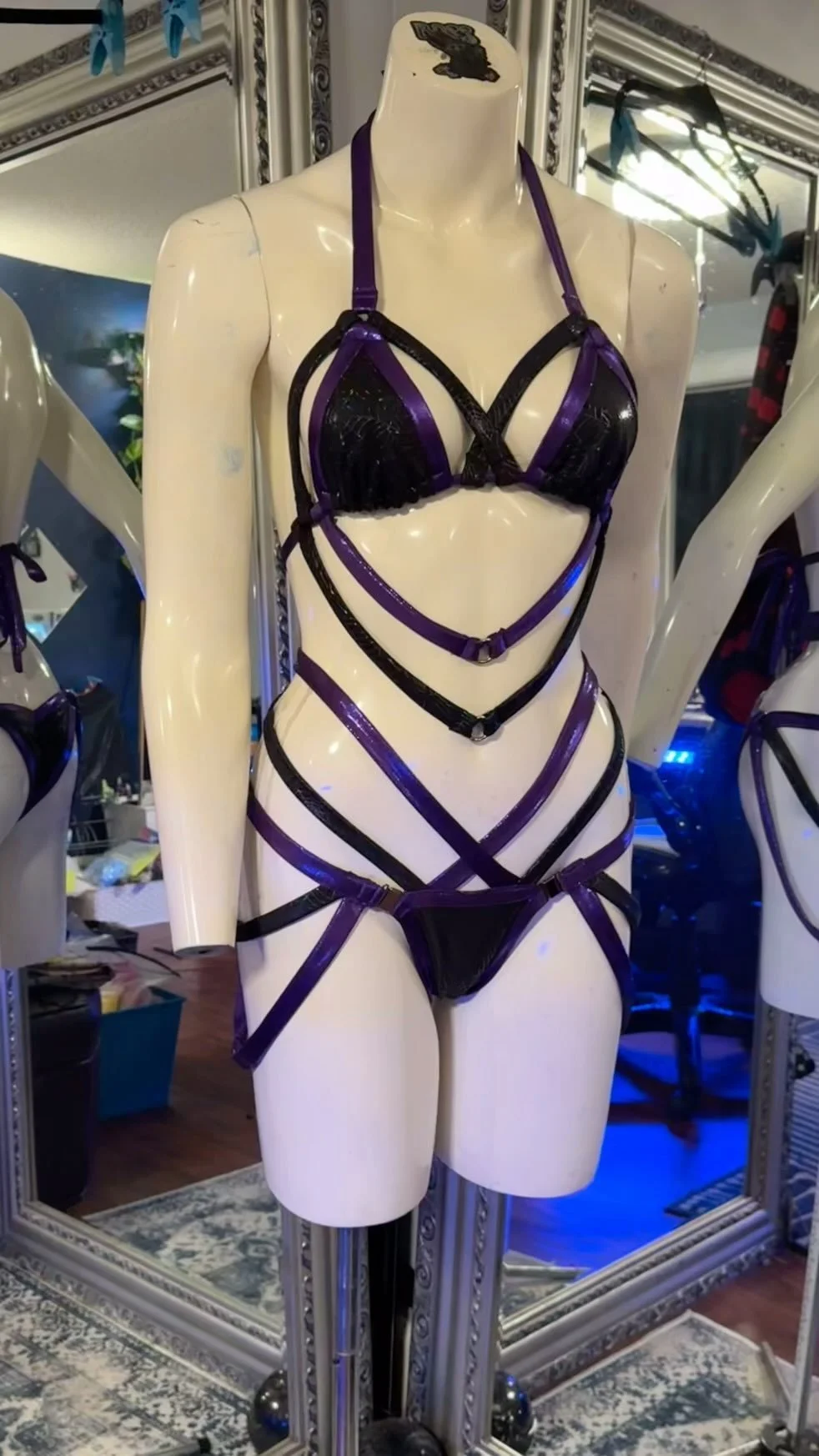 Mannequin wearing strappy black and purple lingerie set.