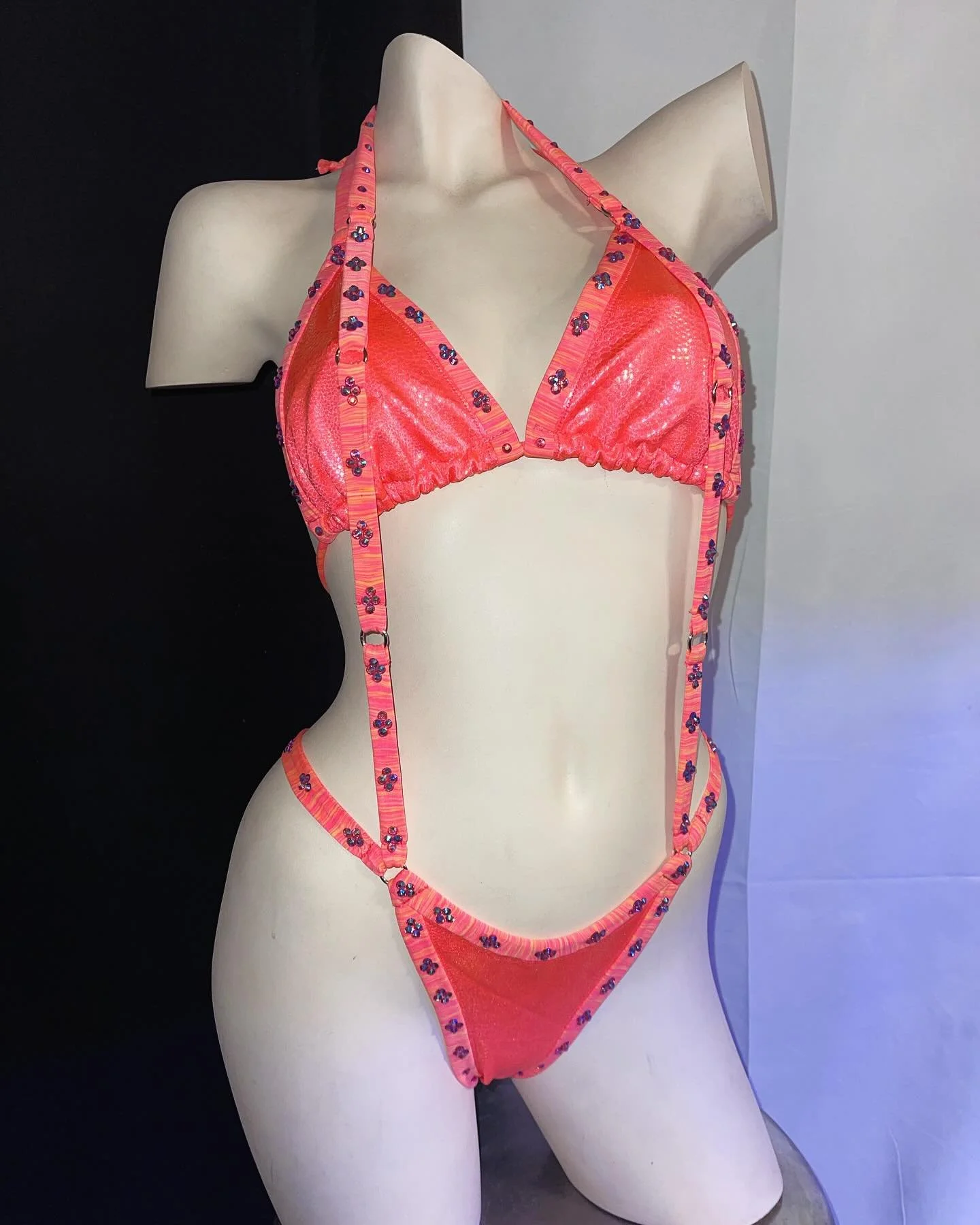 Mannequin wearing a pink bikini with floral patterns.