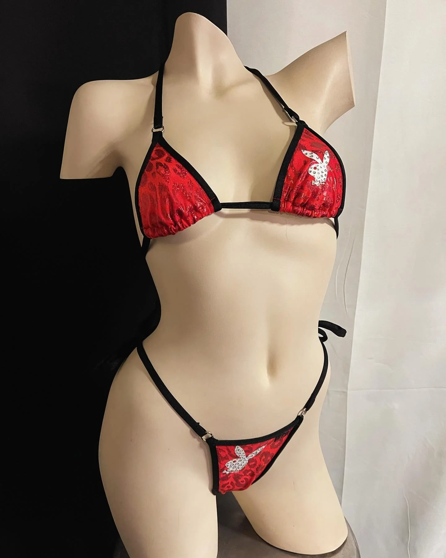 Mannequin wearing a red and black bikini with a white bunny logo.