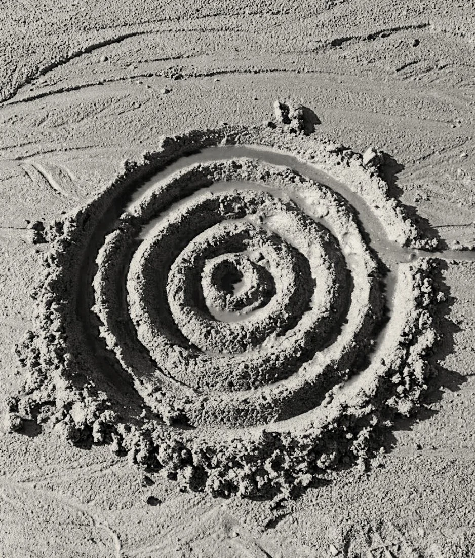Spiral drawn in sand with textured grooves