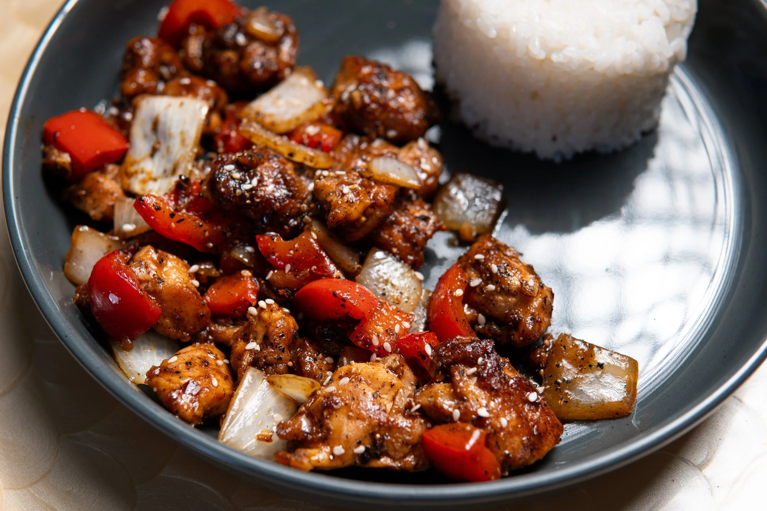 Black Pepper Chicken with peppers, onions, sesame seeds, and rice