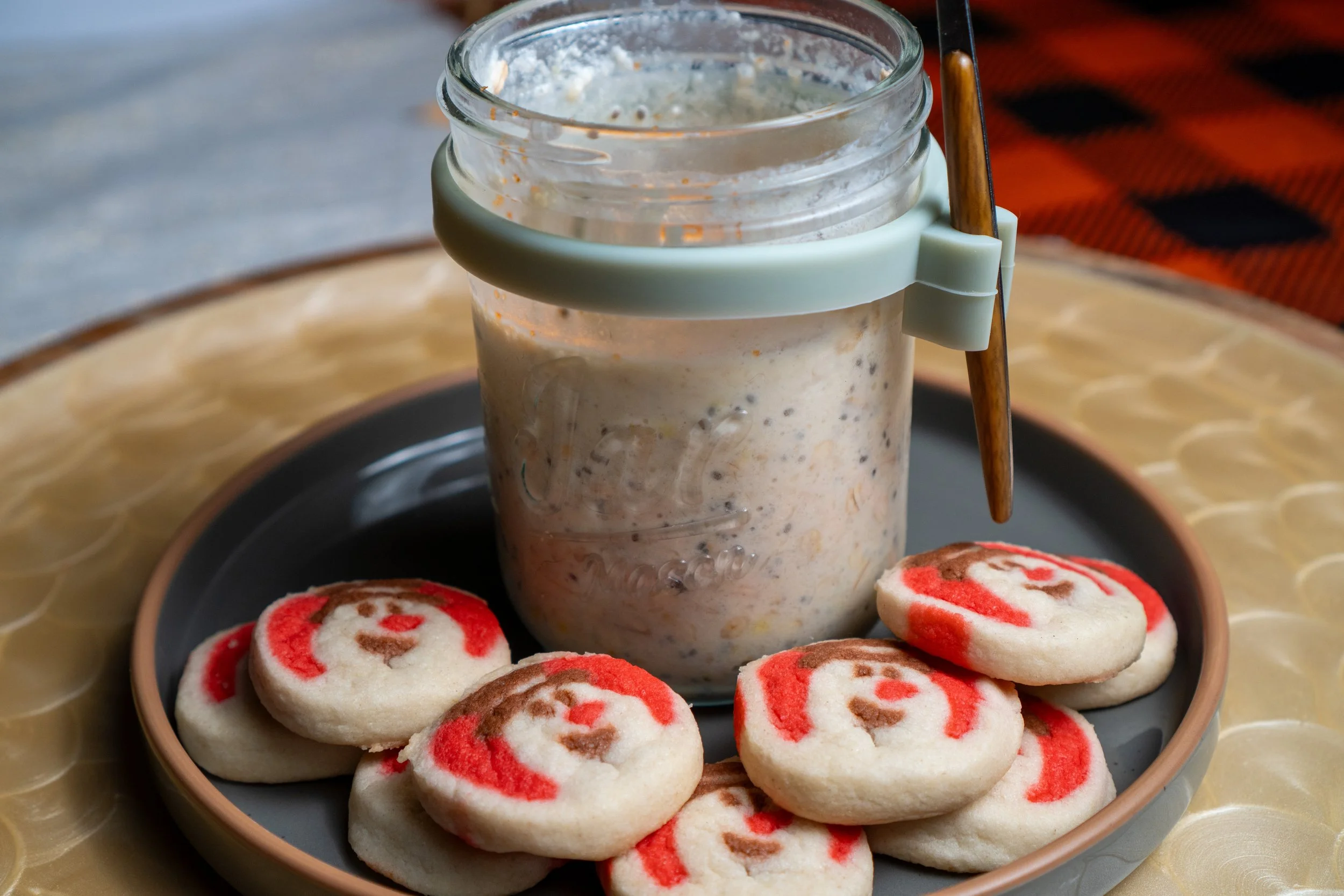 Jar of sugar cookie overnight oats topped with sprinkles on a white marble counter.