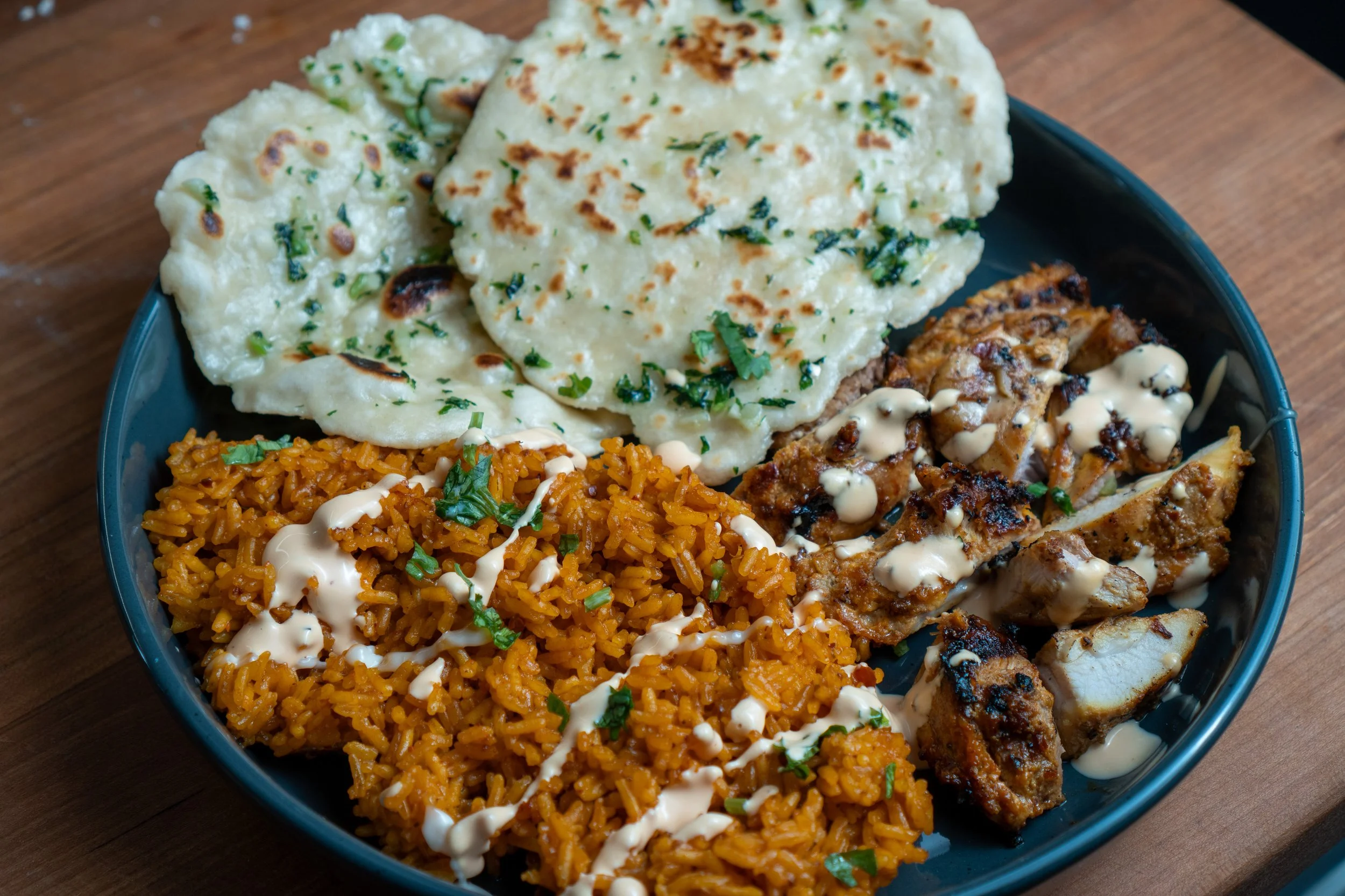 NYC-style chicken and rice plate with homemade garlic naan and white sauce