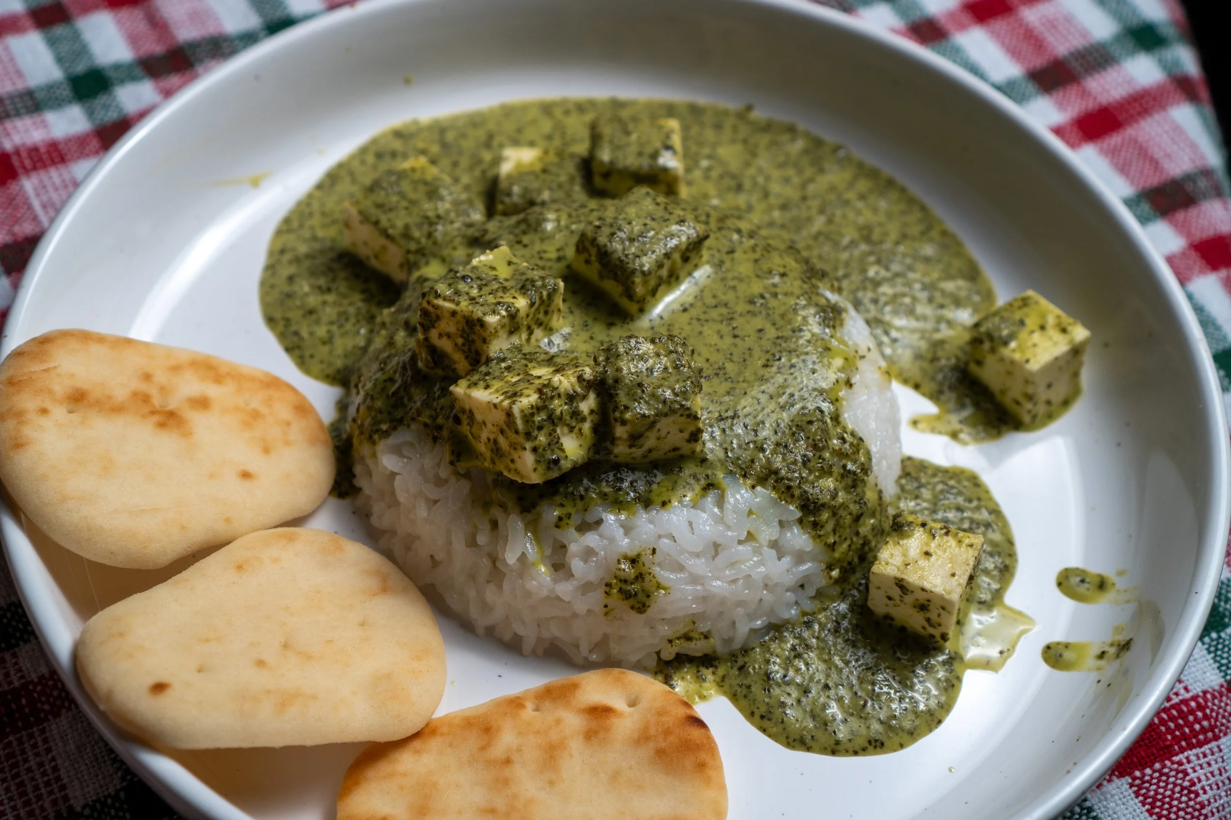 Spinach and mustard green saag with paneer served alongside homemade garlic naan
