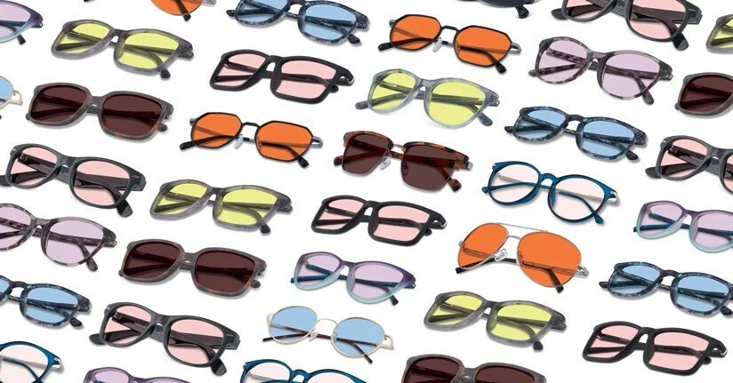 Multiple pairs of sunglasses with various frame styles and lens colors arranged on a white background.