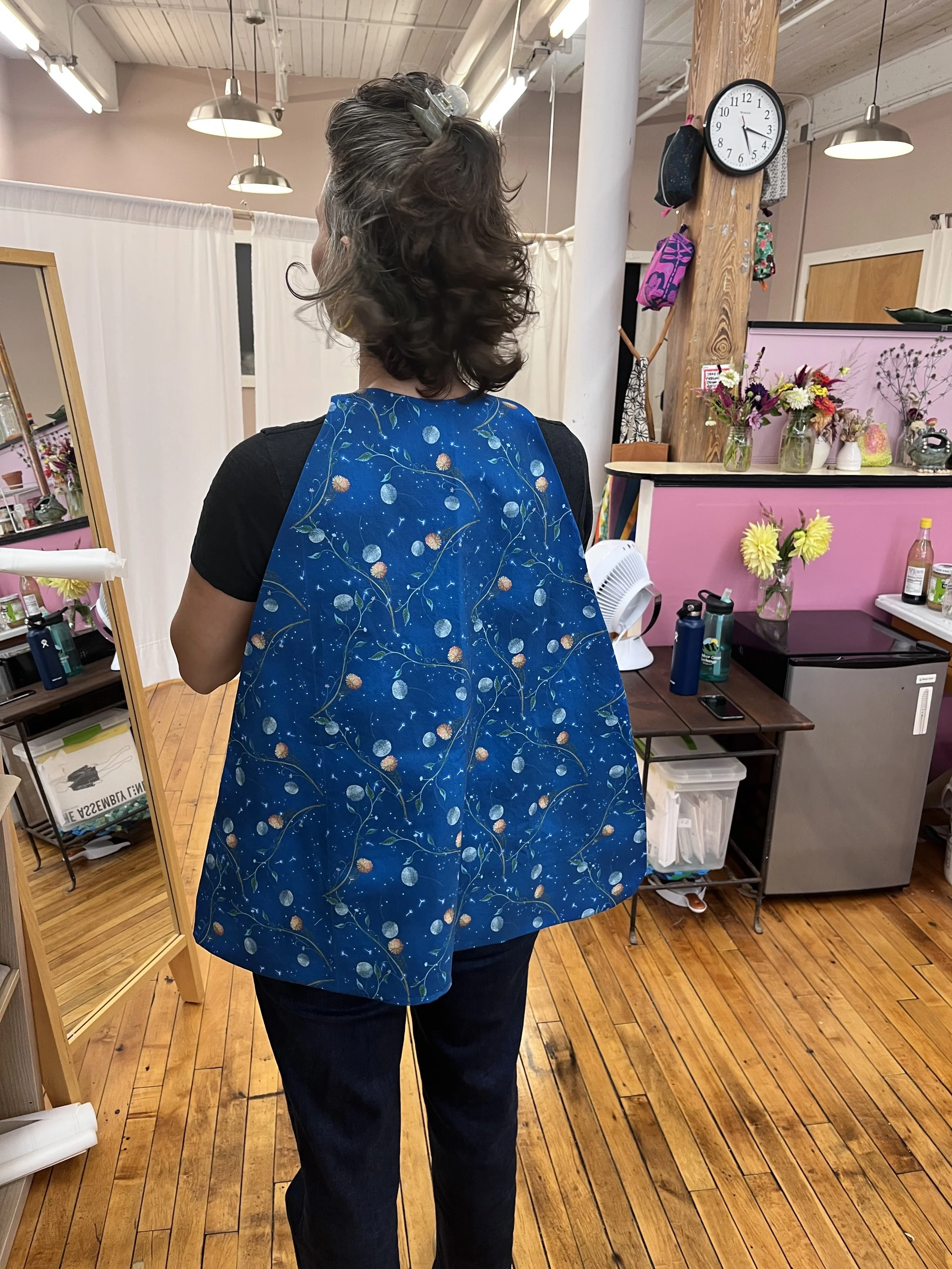 Student who learned to sew at Grove House wearing a cape she made for her kids