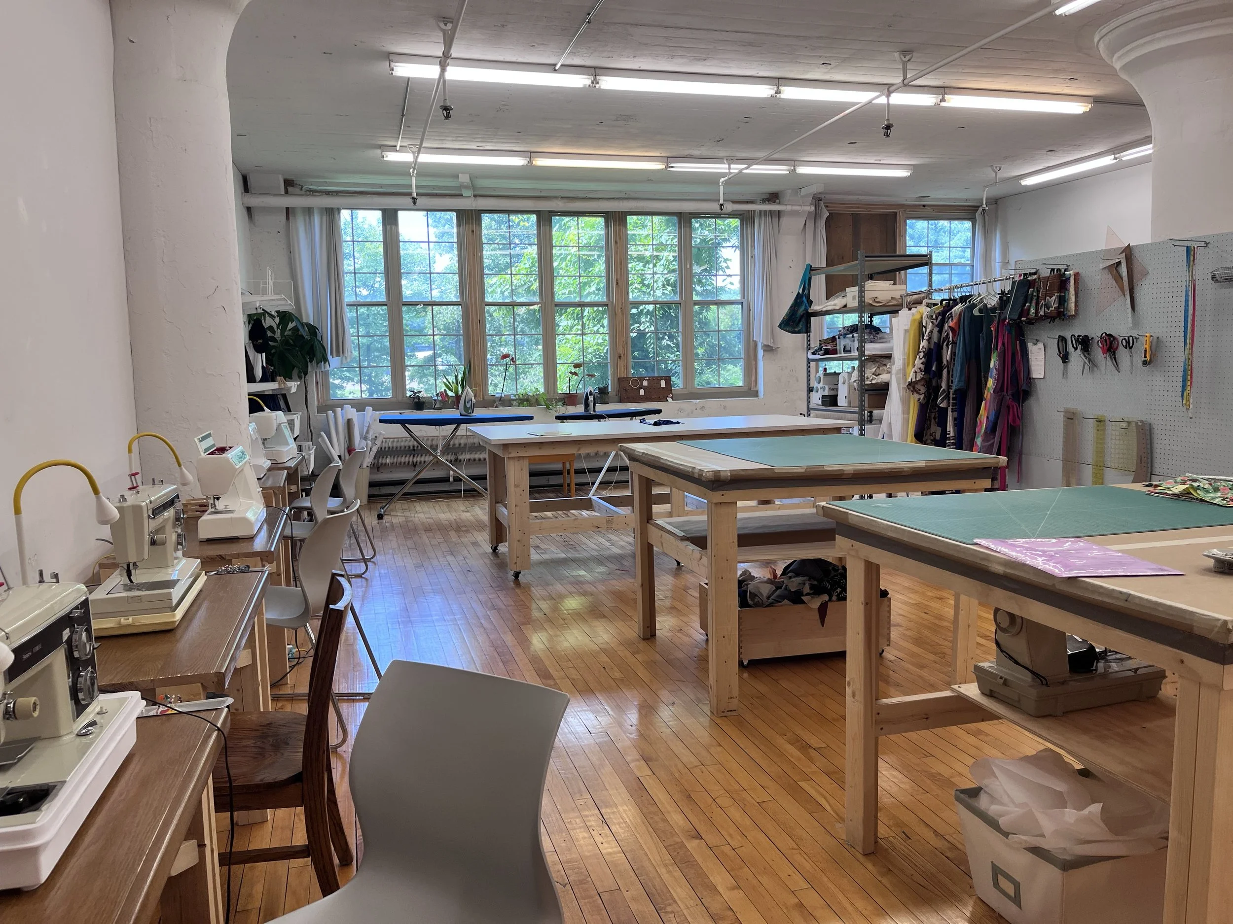 A view of the sewing tables and fabric work tables in the sewing classroom at Grove House