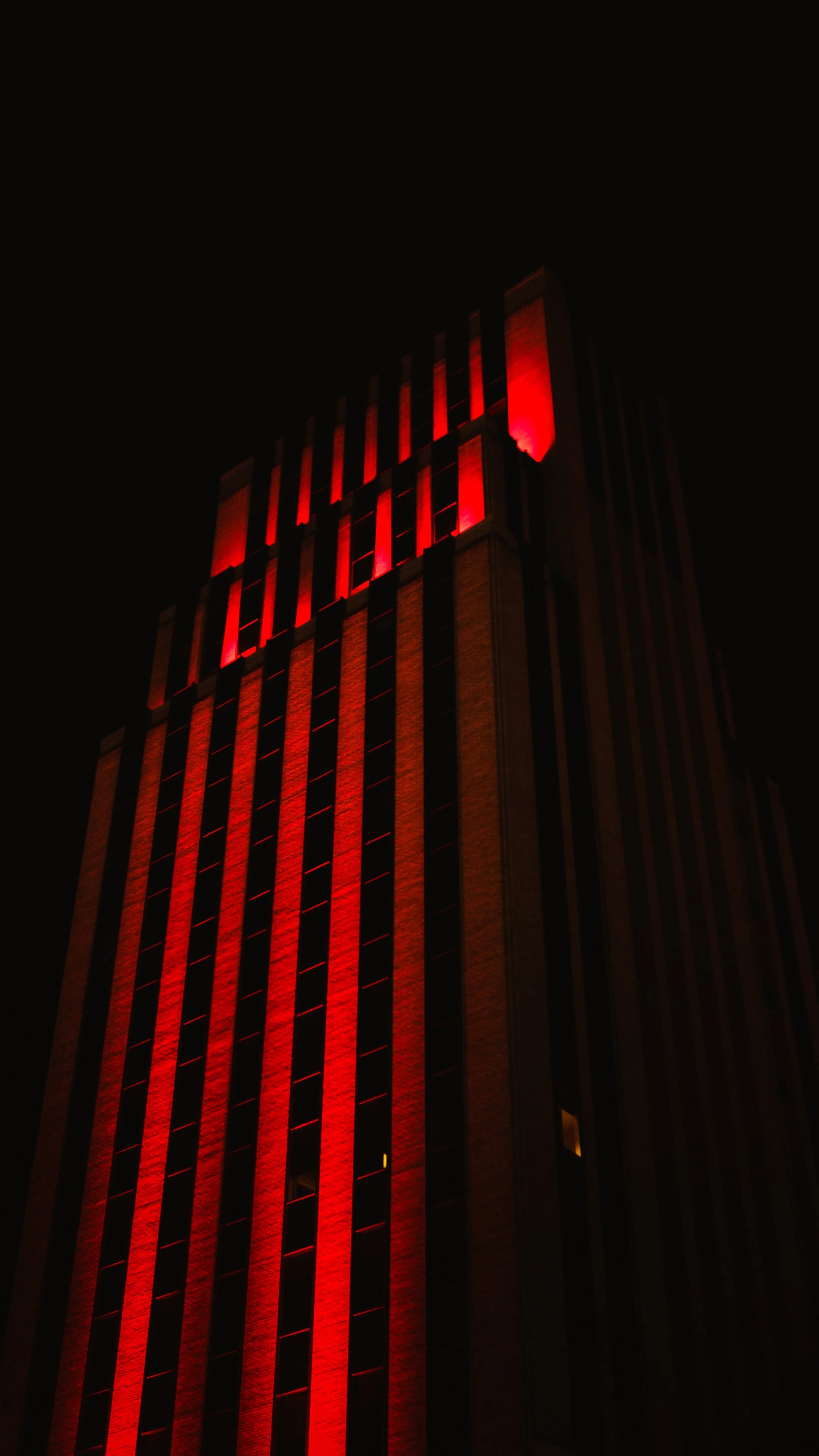 A tall building at night illuminated with red lights taken in Dallas Texas