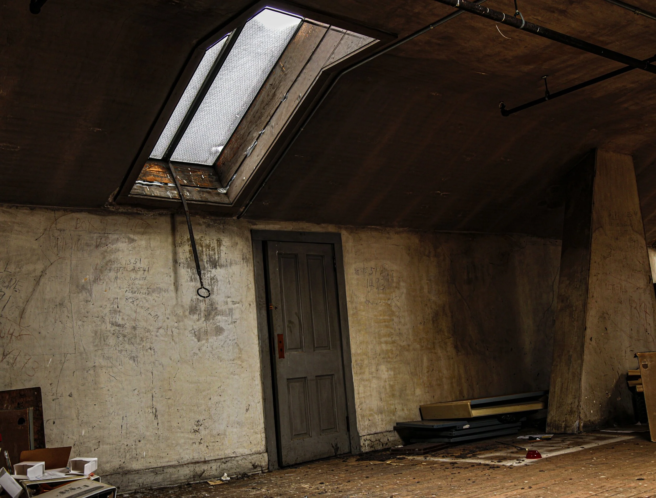 An empty, dirty hospital gurney in a dark, abandoned room with stained walls and minimal lighting.