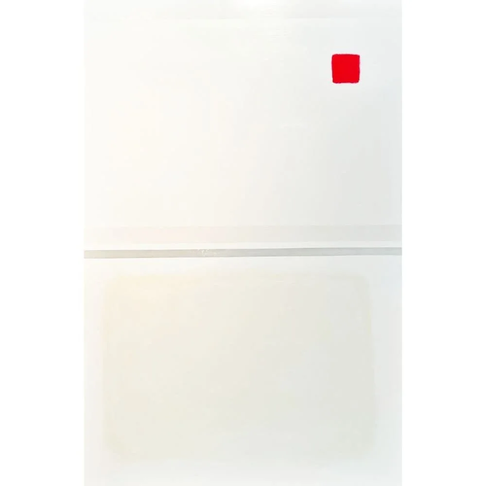 A minimalist white wall with a small red square decoration near the top right corner.