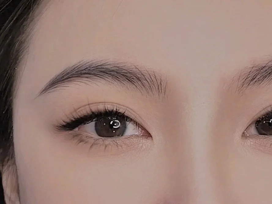 Close-up of a woman's eyes with natural makeup, showcasing well-groomed eyebrows, long eyelashes, and clear skin.
nano brows, microblading, lip blush, eyeliner and powder brows.